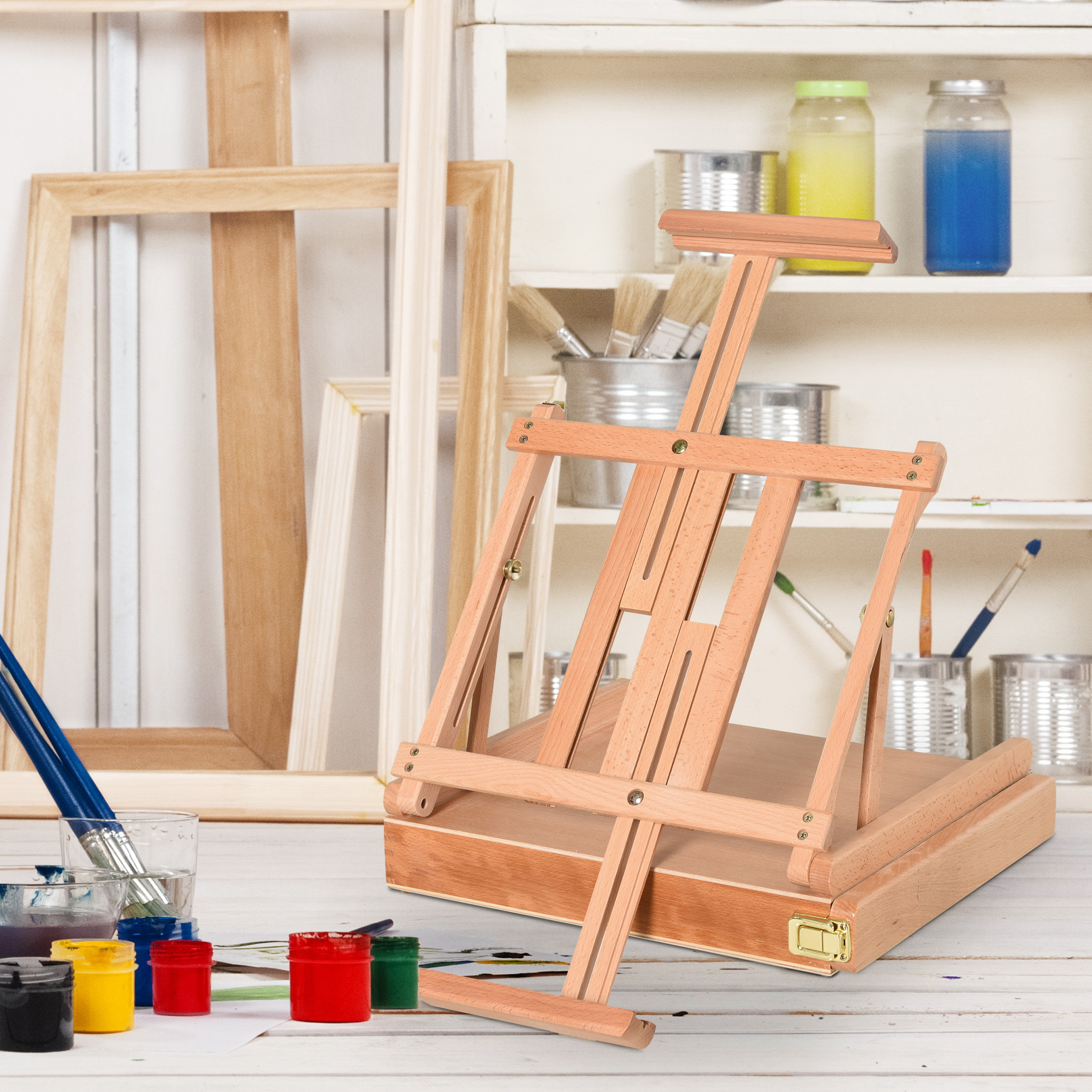 Cavalletto in legno con materiali per l'arte. Tela, pennelli e colori visibili. Sfondo bianco.