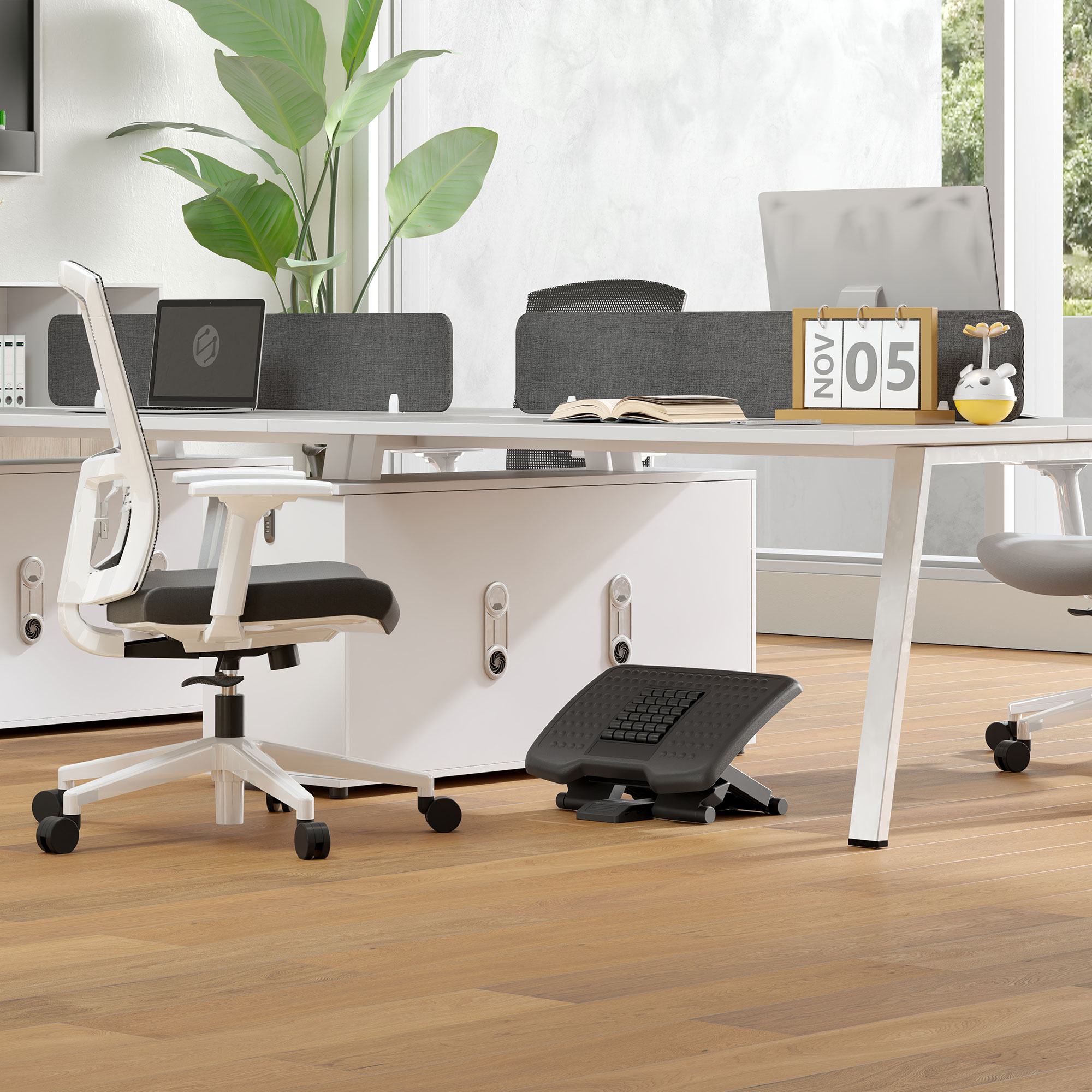 Ufficio moderno con scrivania bianca, sedia, poggiapiedi e monitor. Pavimento in legno e piante.