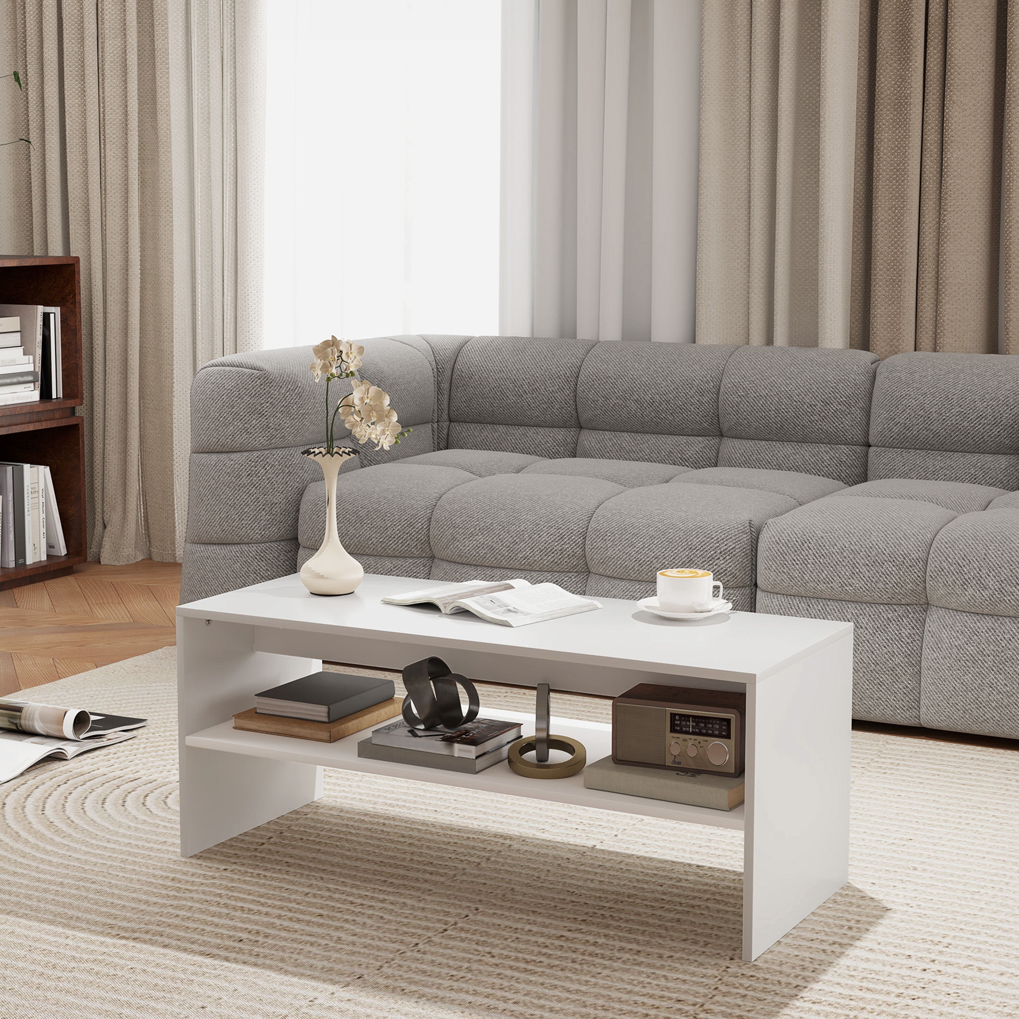 Tavolino bianco con libri e decorazioni sul ripiano inferiore.