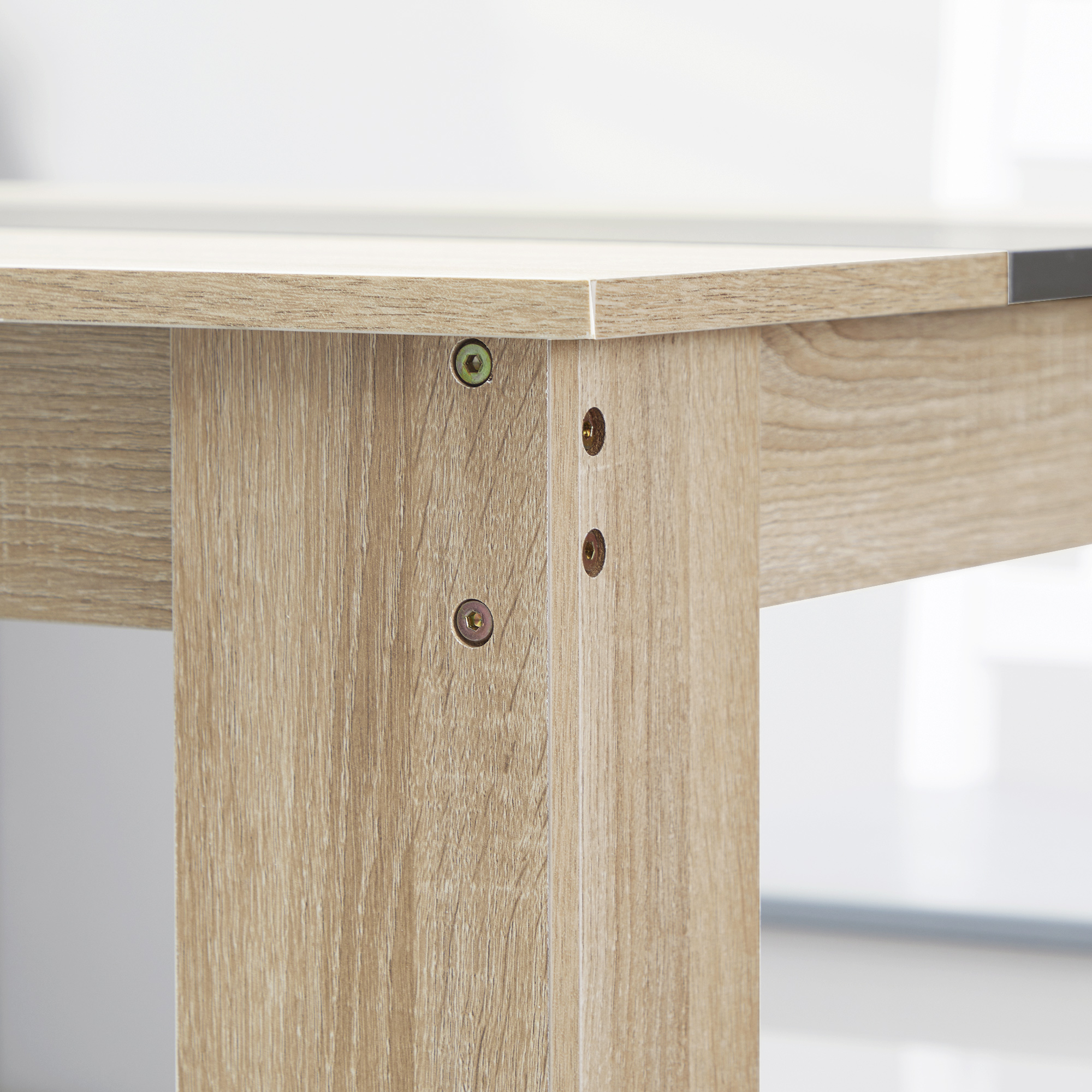 Primo piano di un angolo di tavolo in legno. Legno chiaro con viti. L'angolo mostra la costruzione.