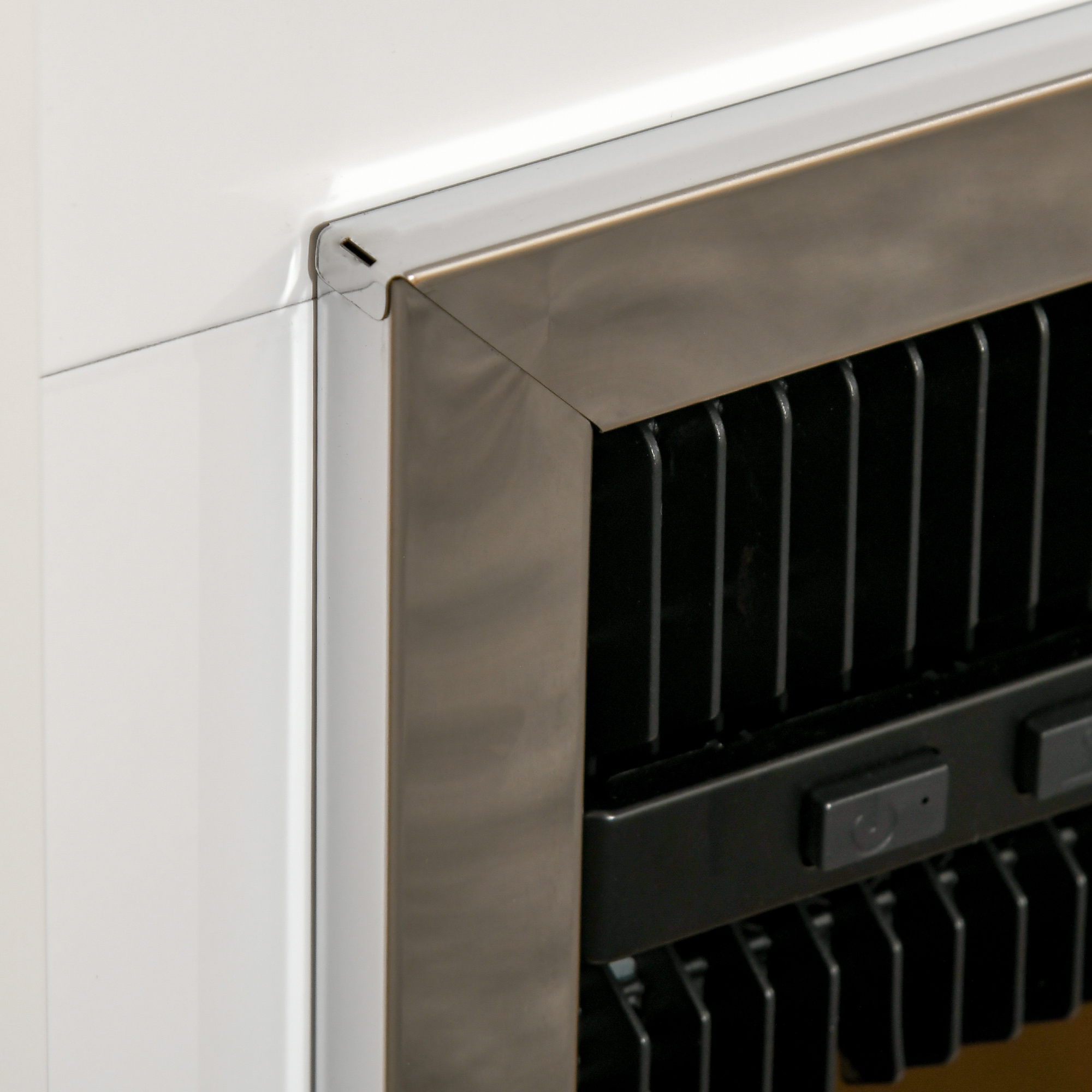 Primo piano di un caminetto con cornice argentata e interno nero.