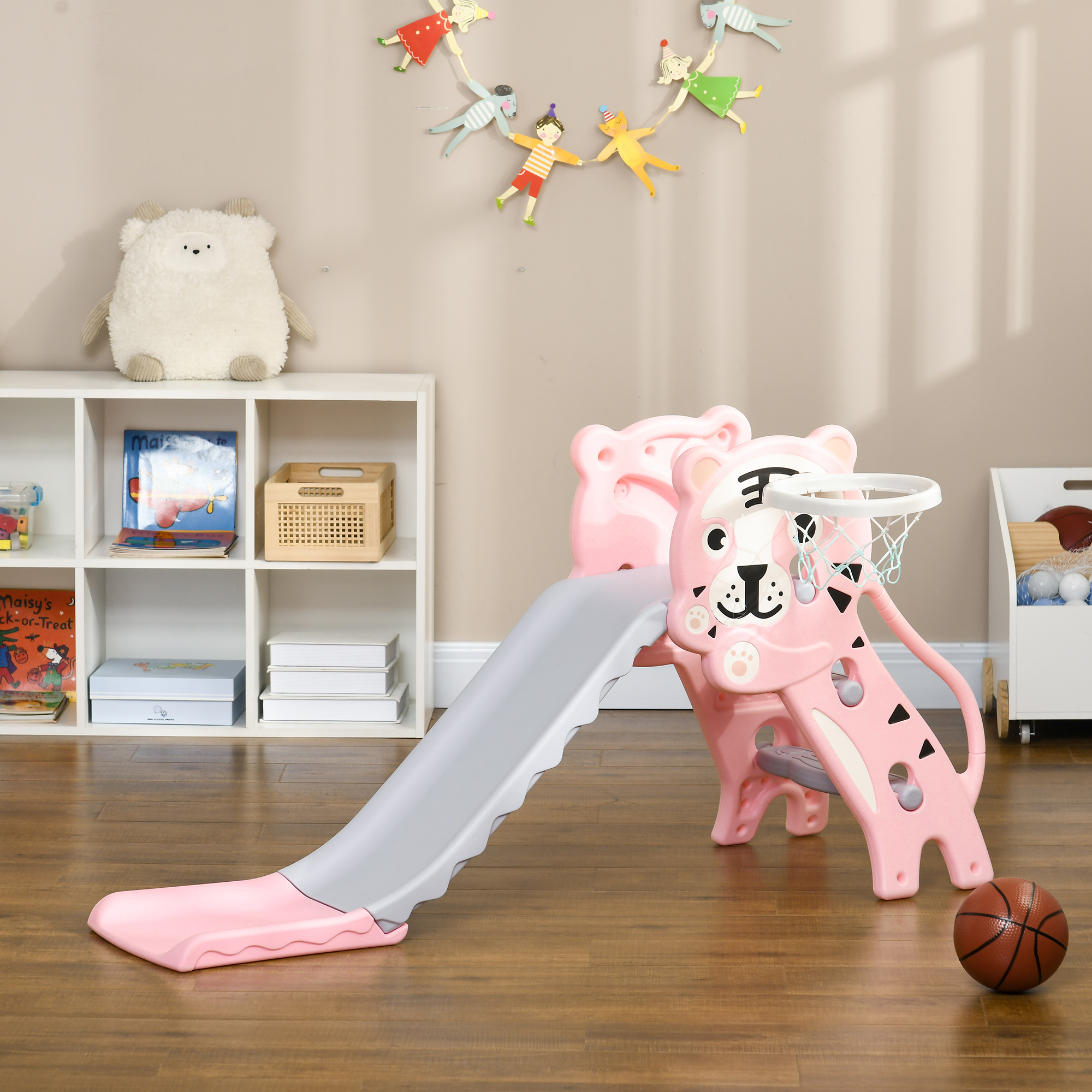 Scivolo rosa e canestro da basket. Lo scivolo presenta un design a forma di faccia di tigre. Pallone e giocattoli visibili.