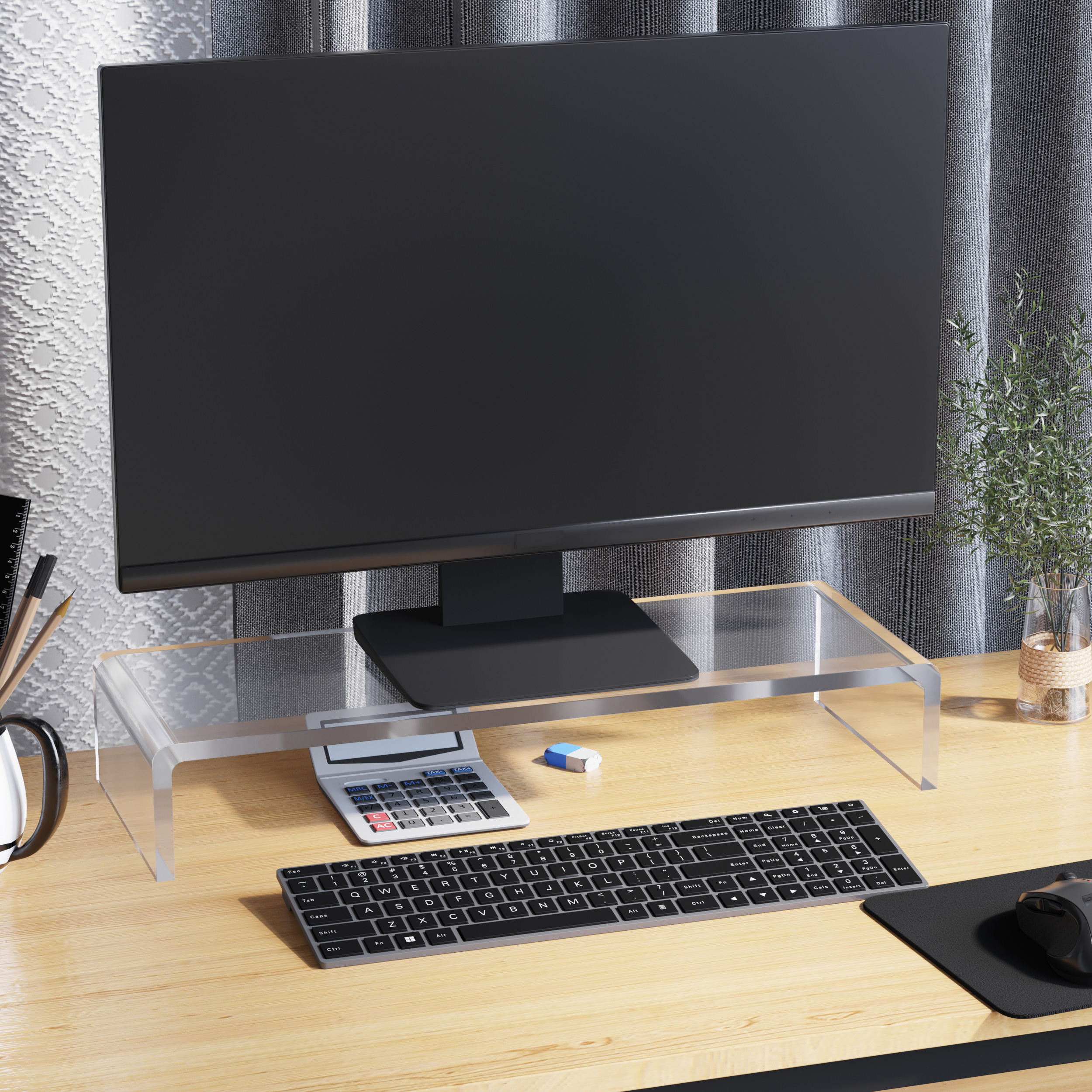 Un monitor di computer su un supporto in acrilico trasparente. Una tastiera, una calcolatrice e un mouse sulla scrivania di legno.