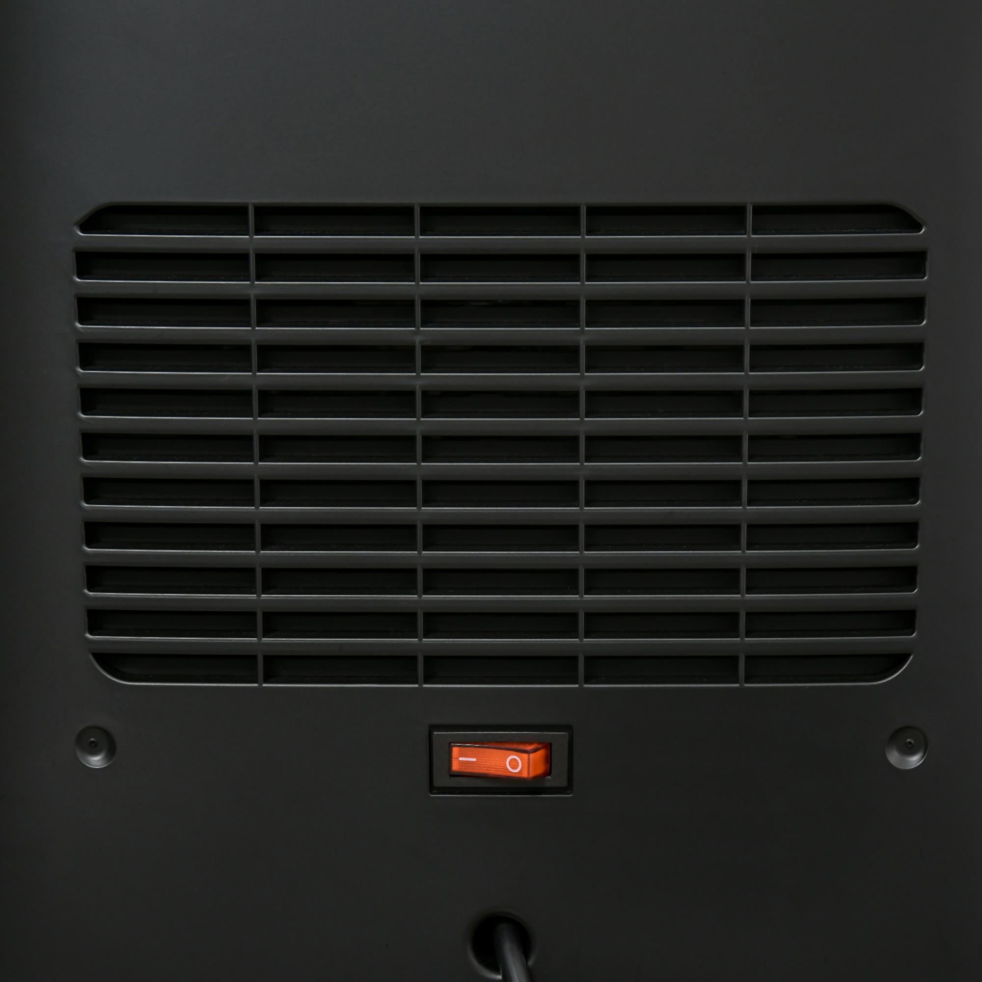 Eine schwarze Platte mit einem Gitter und einem orangefarbenen Netzschalter.