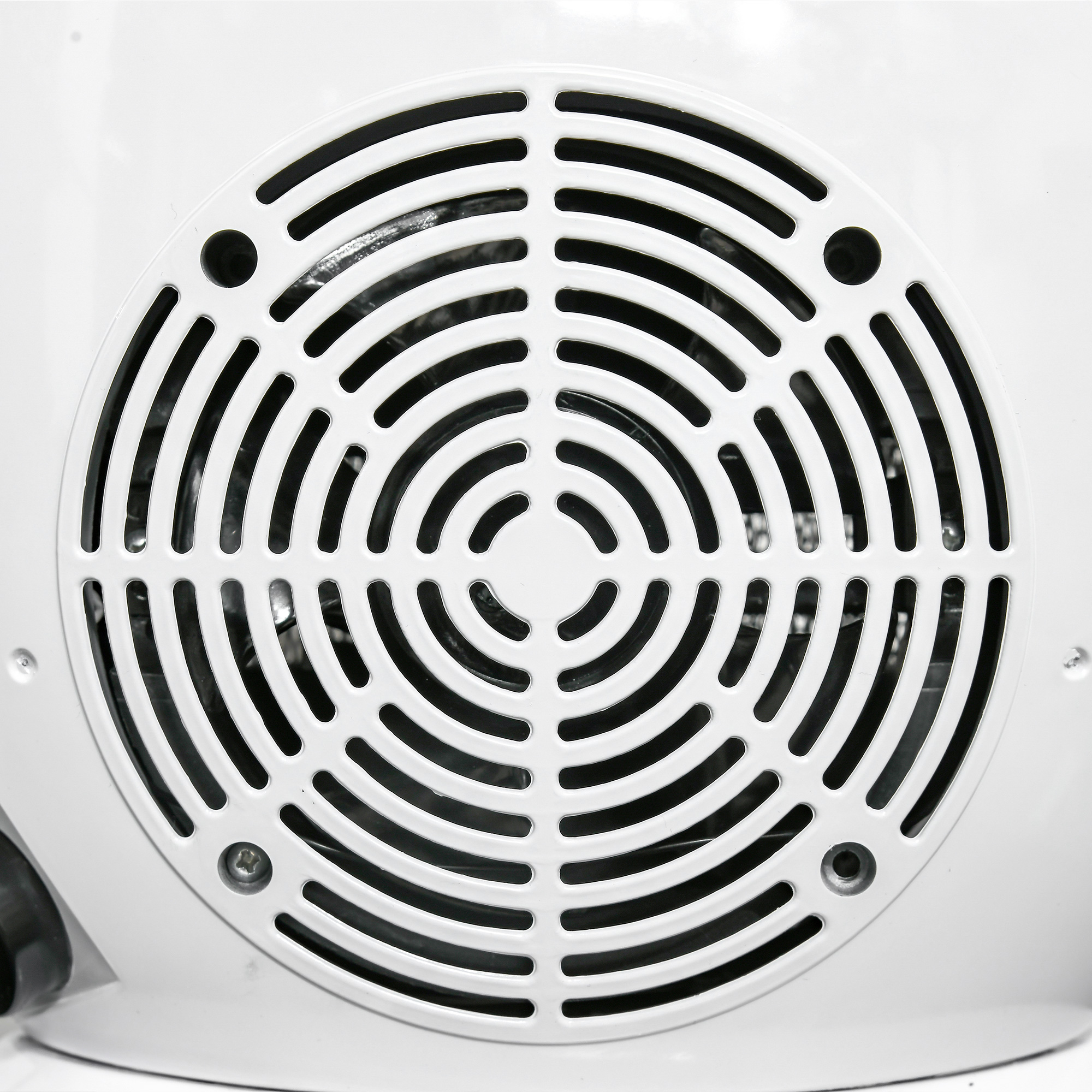 Primo piano di una griglia di ventilatore bianca con aperture circolari concentriche. Il centro è solido.