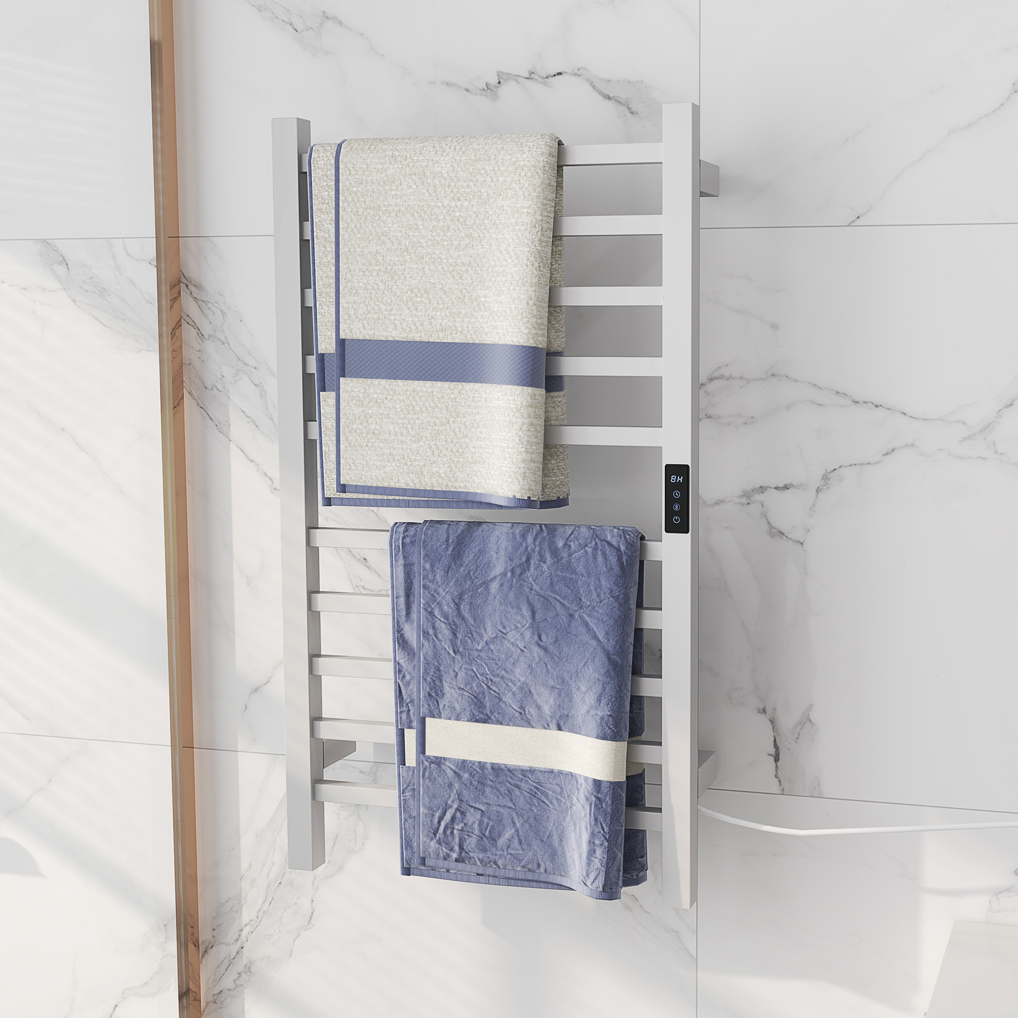 Uno scaldasalviette bianco con due asciugamani appesi. Il muro è in marmo bianco.