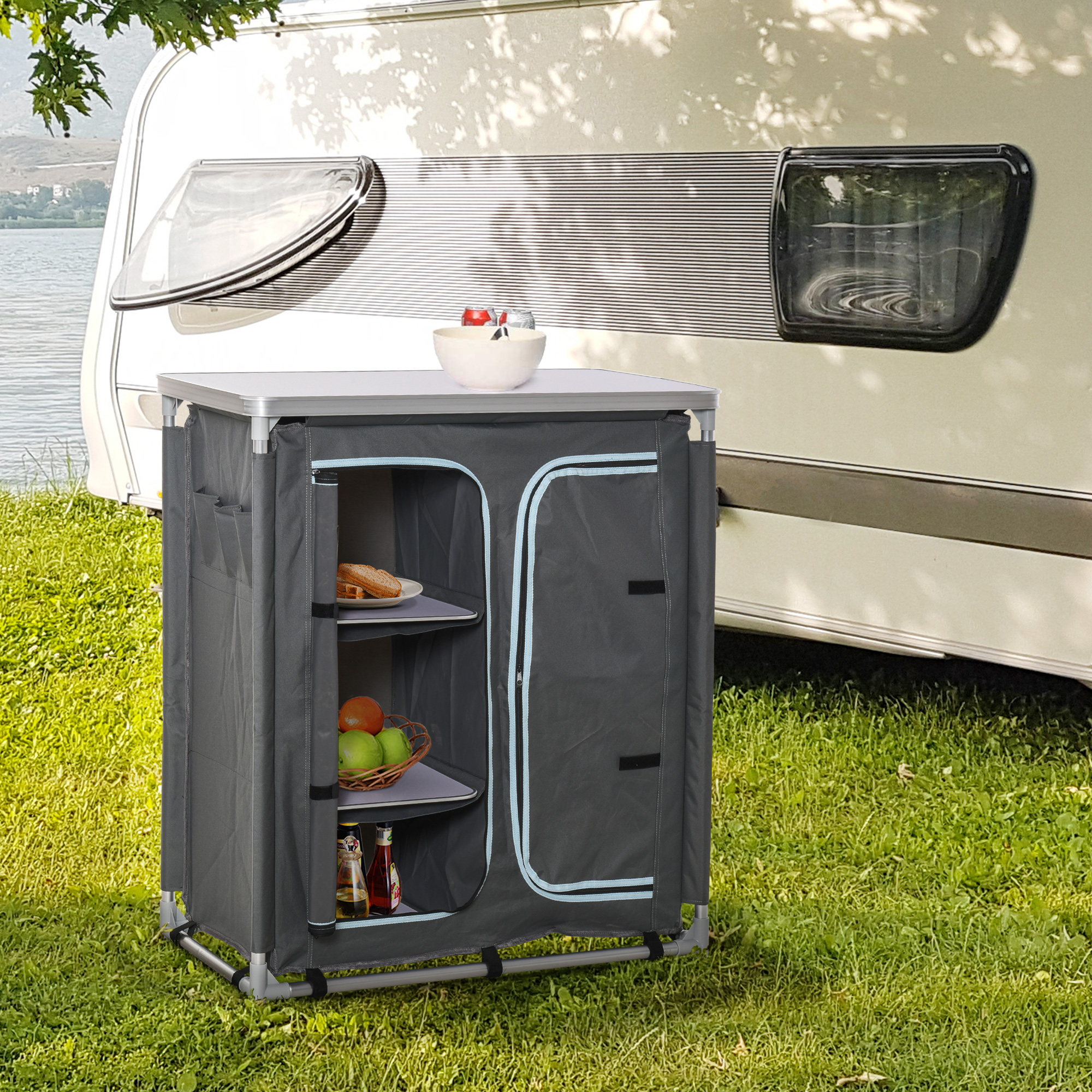 Un armadio da campeggio grigio con cibo all'interno. È fuori con un camper.