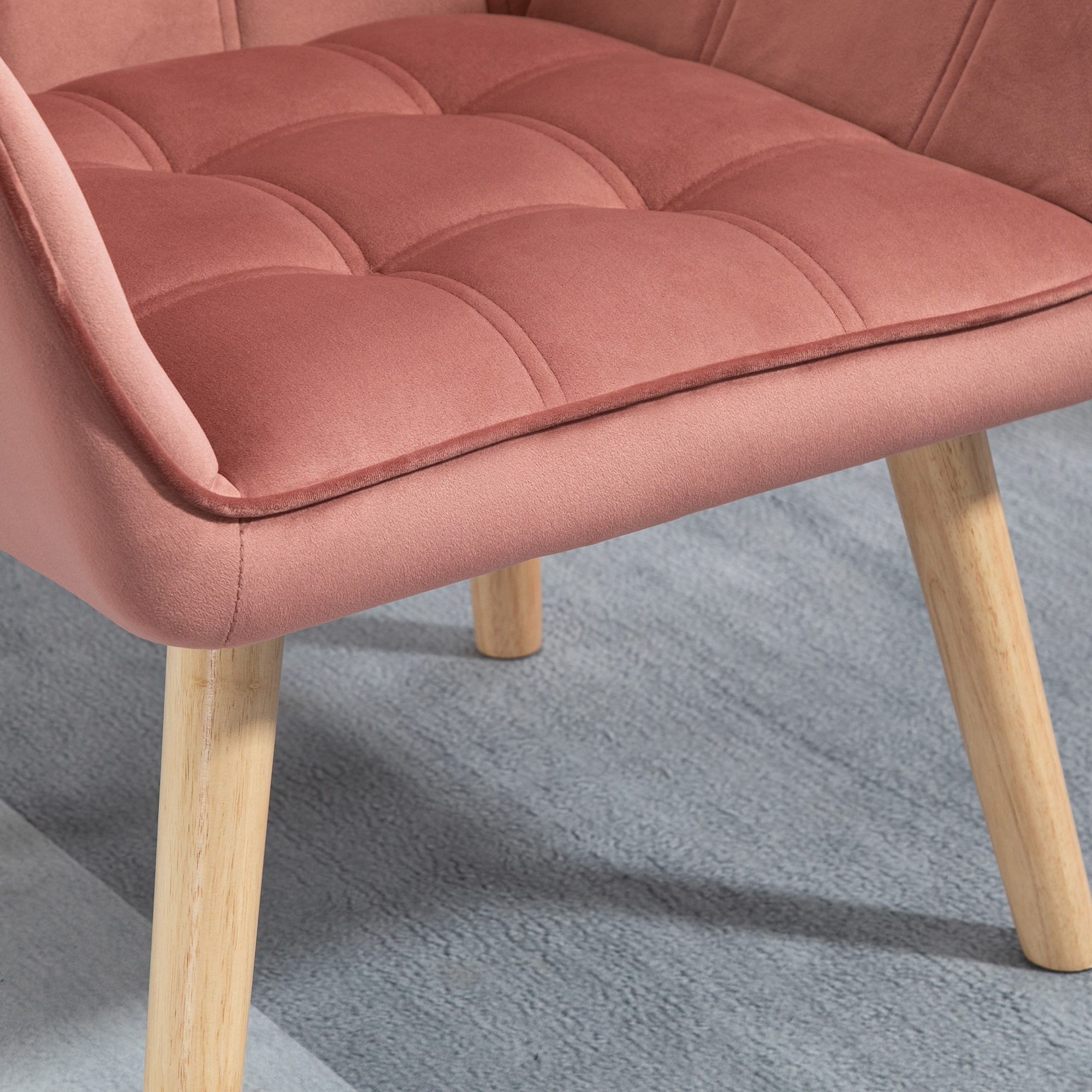 Sedia in velluto rosa con gambe in legno. La seduta è trapuntata.
