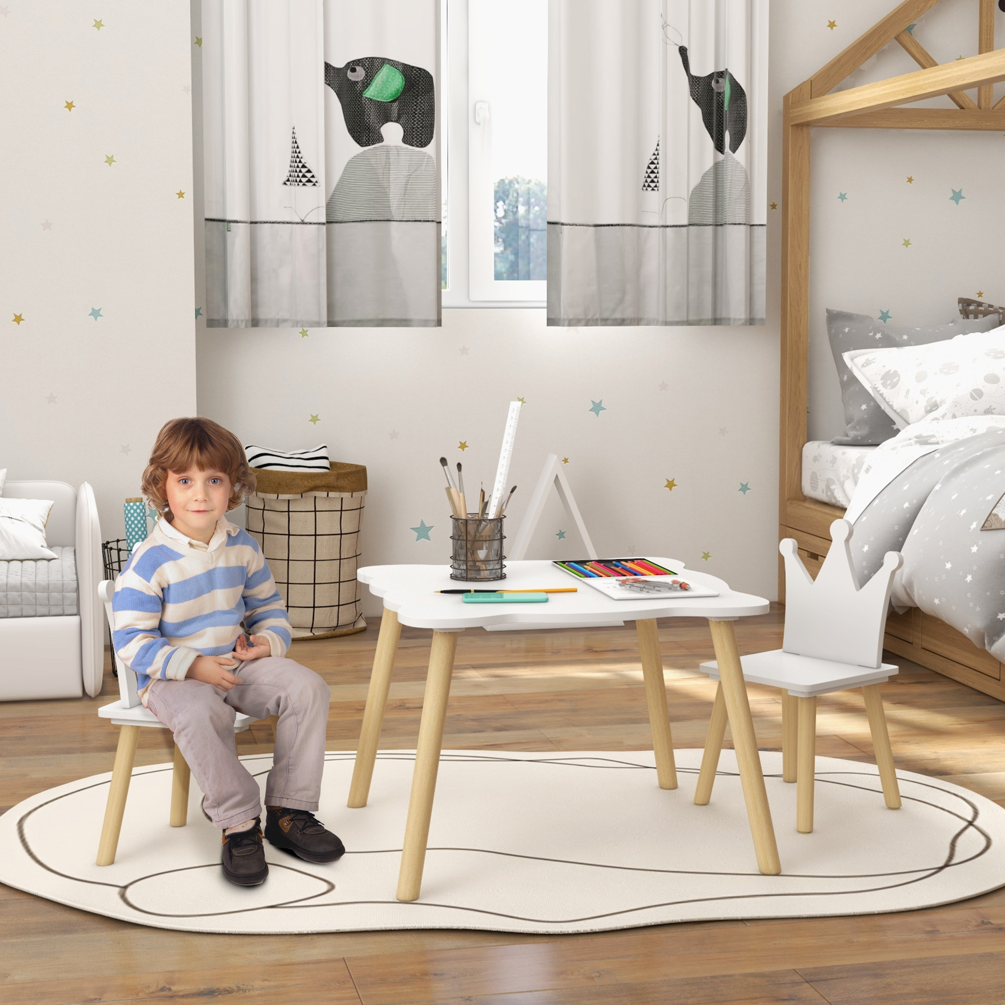 Un bambino è seduto a un tavolo bianco in una stanza. Tende, letto e altri mobili sono in vista.