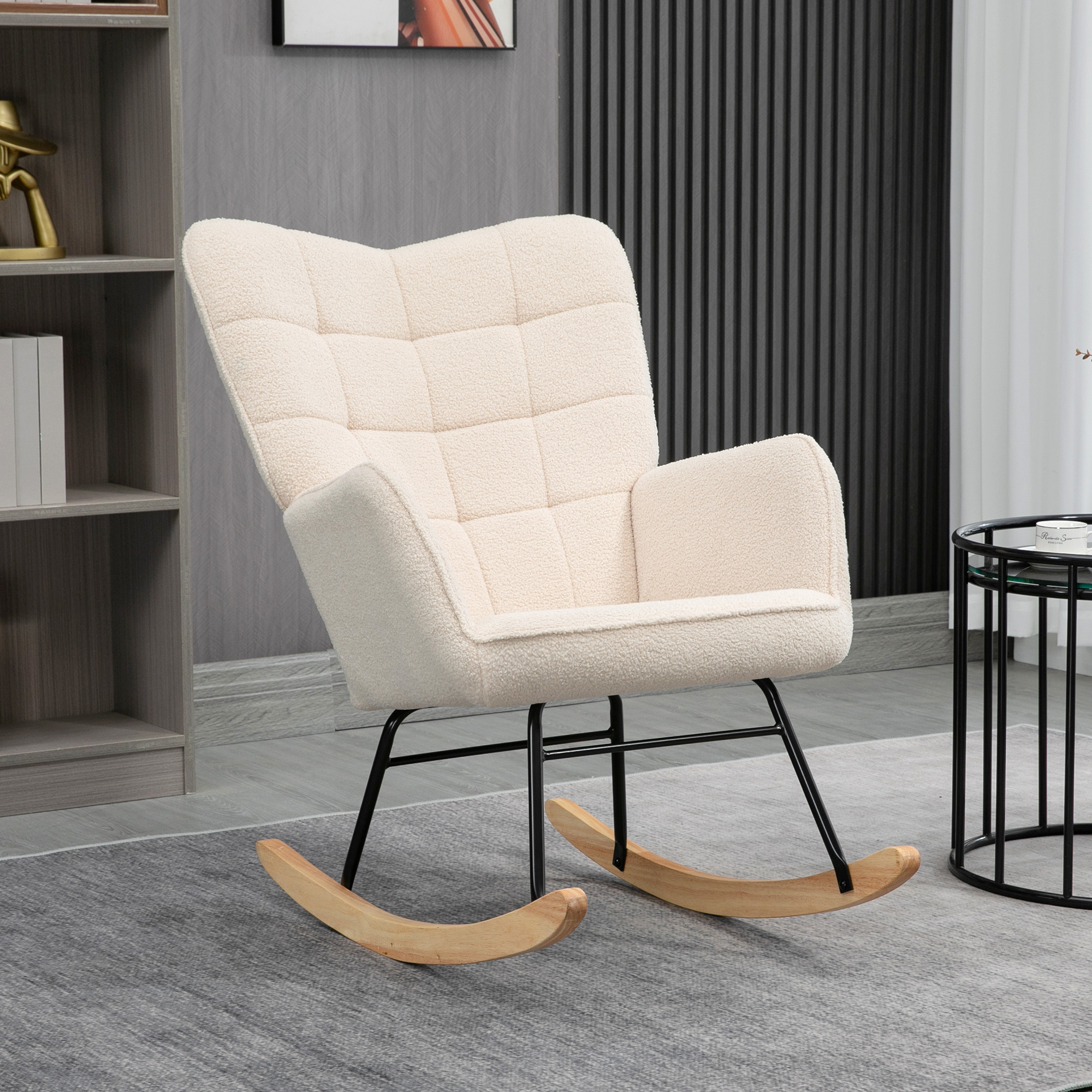 Sedia a dondolo color crema con gambe nere, su un tappeto.