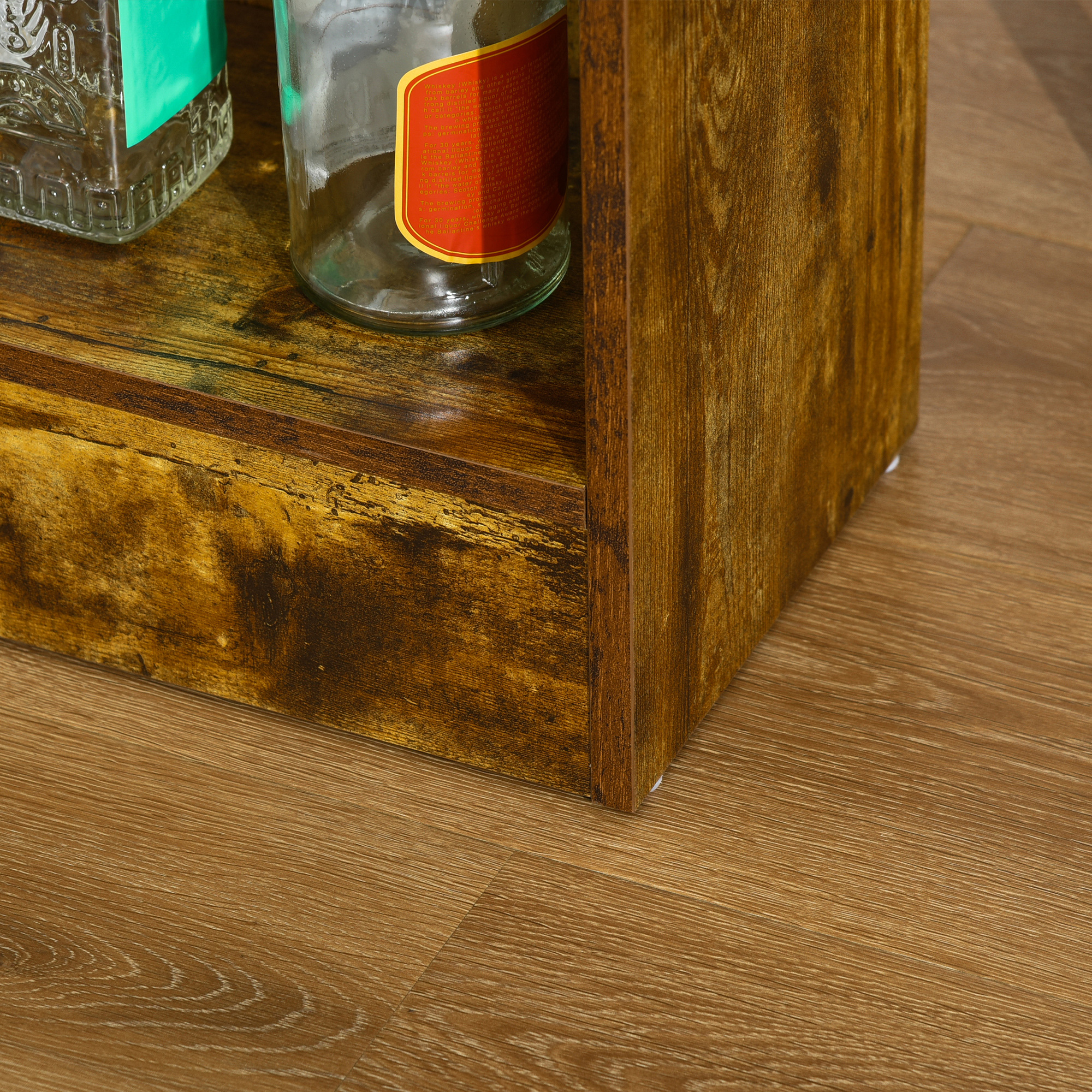 Mensola in legno con bottiglie sopra. La mensola ha un aspetto invecchiato, con pavimento in legno.