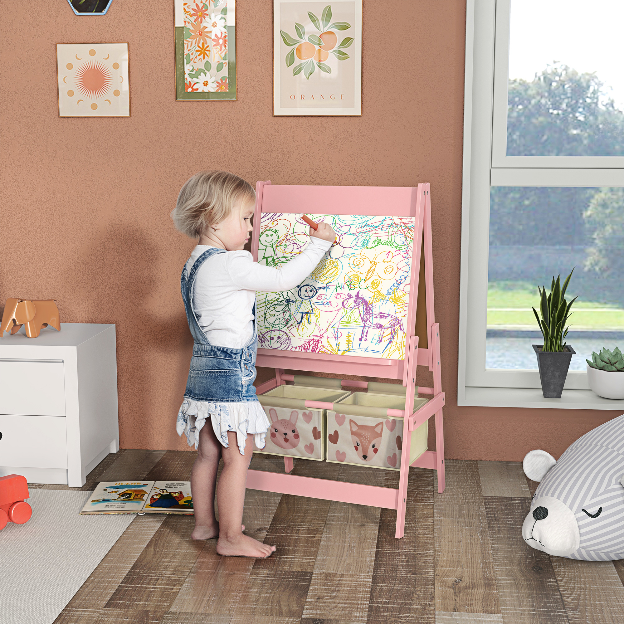 Bambino che disegna su un cavalletto rosa.