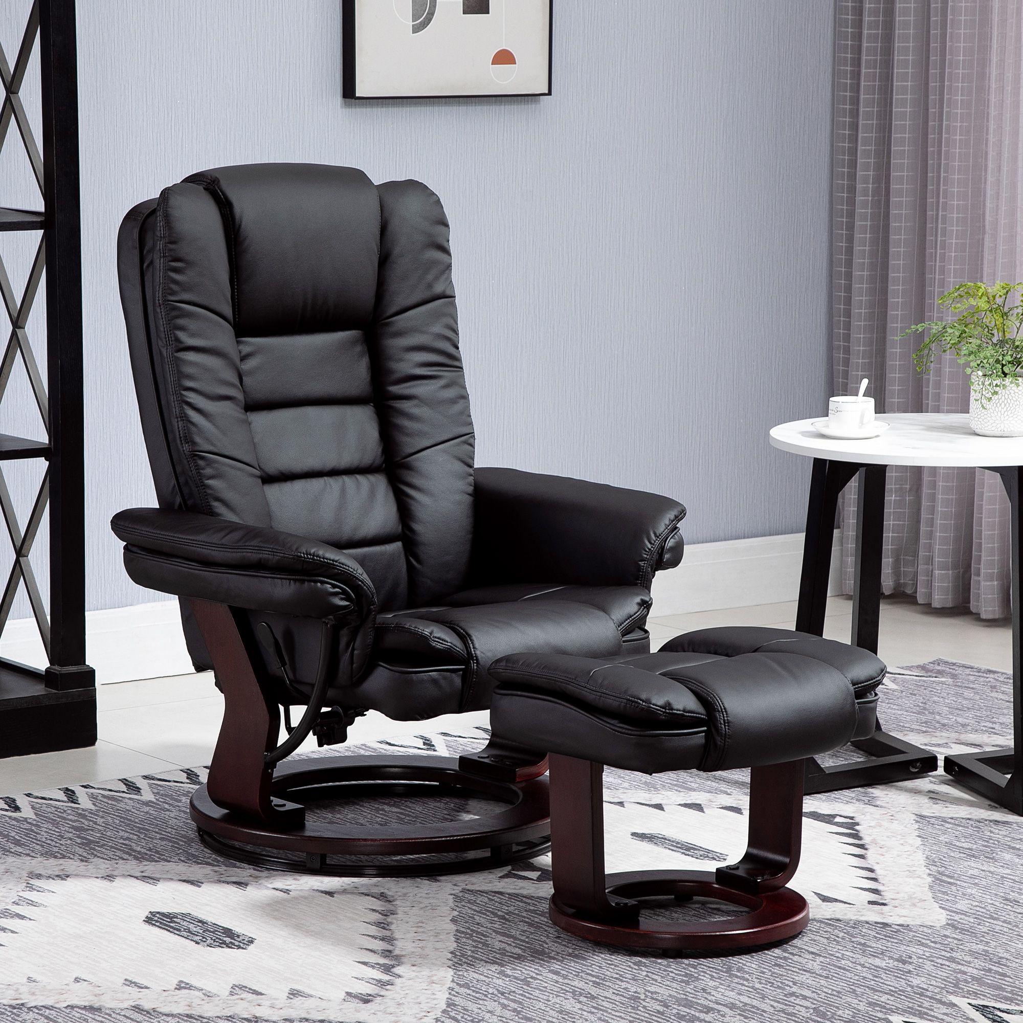 Poltrona reclinabile in pelle nera con poggiapiedi in una stanza. Un tavolino con una pianta è nelle vicinanze.