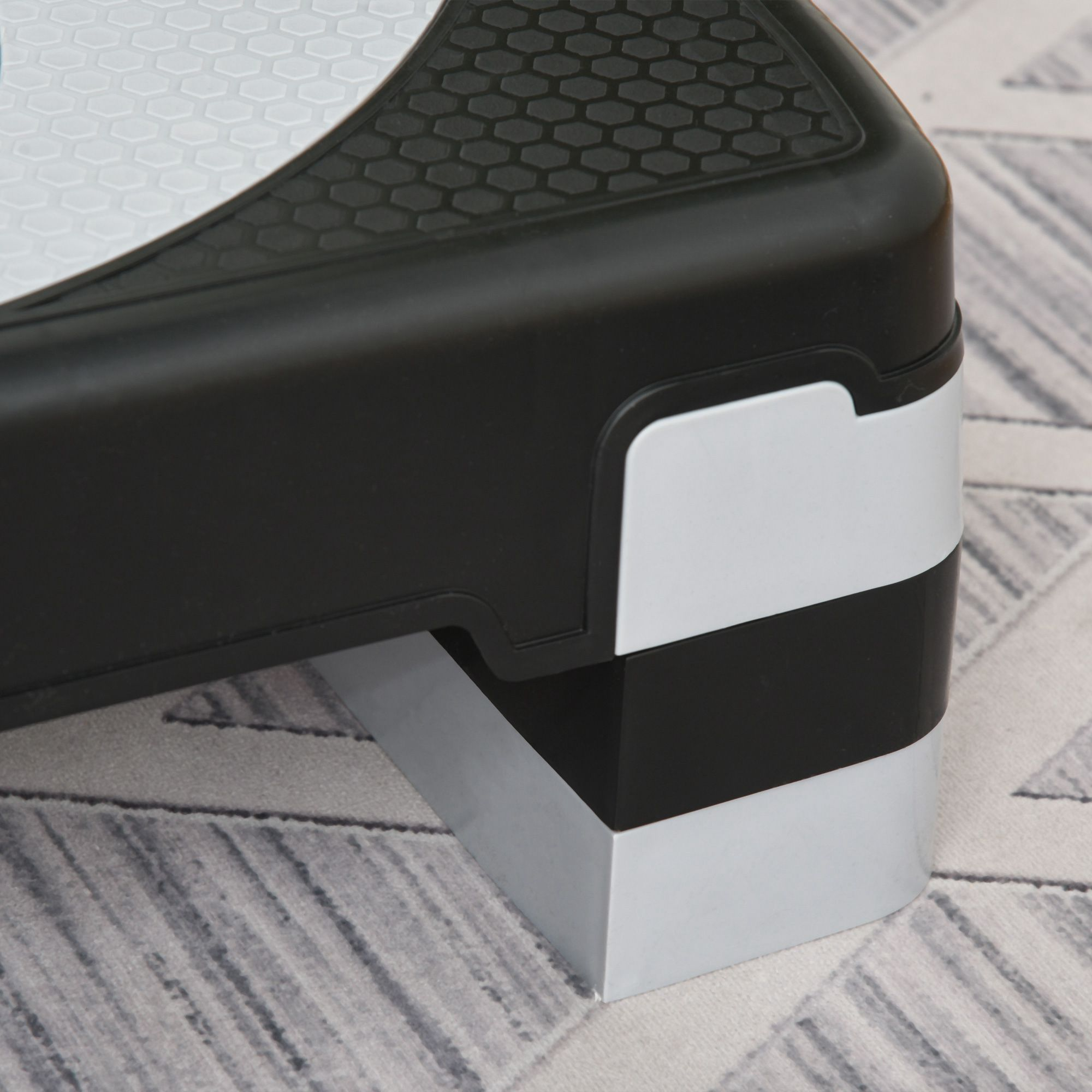 Primo piano di un angolo di una piattaforma di step bianca e nera. La superficie superiore ha un design strutturato.