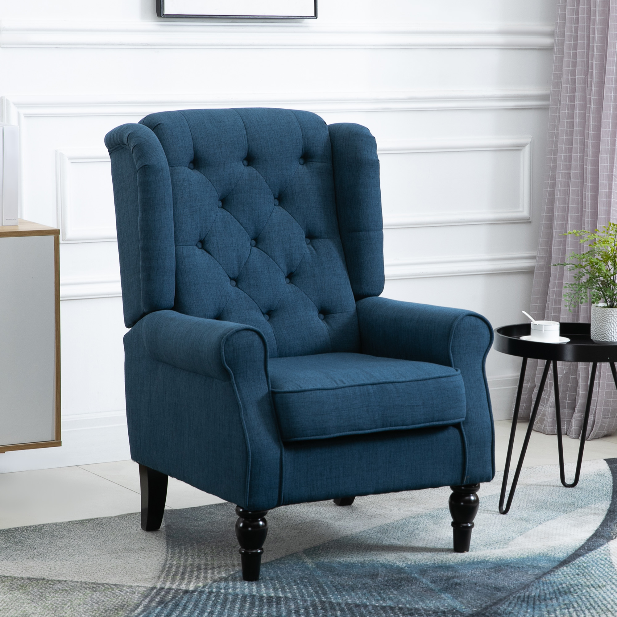 Poltrona blu con schienale alato e tavolino nero in un soggiorno moderno.