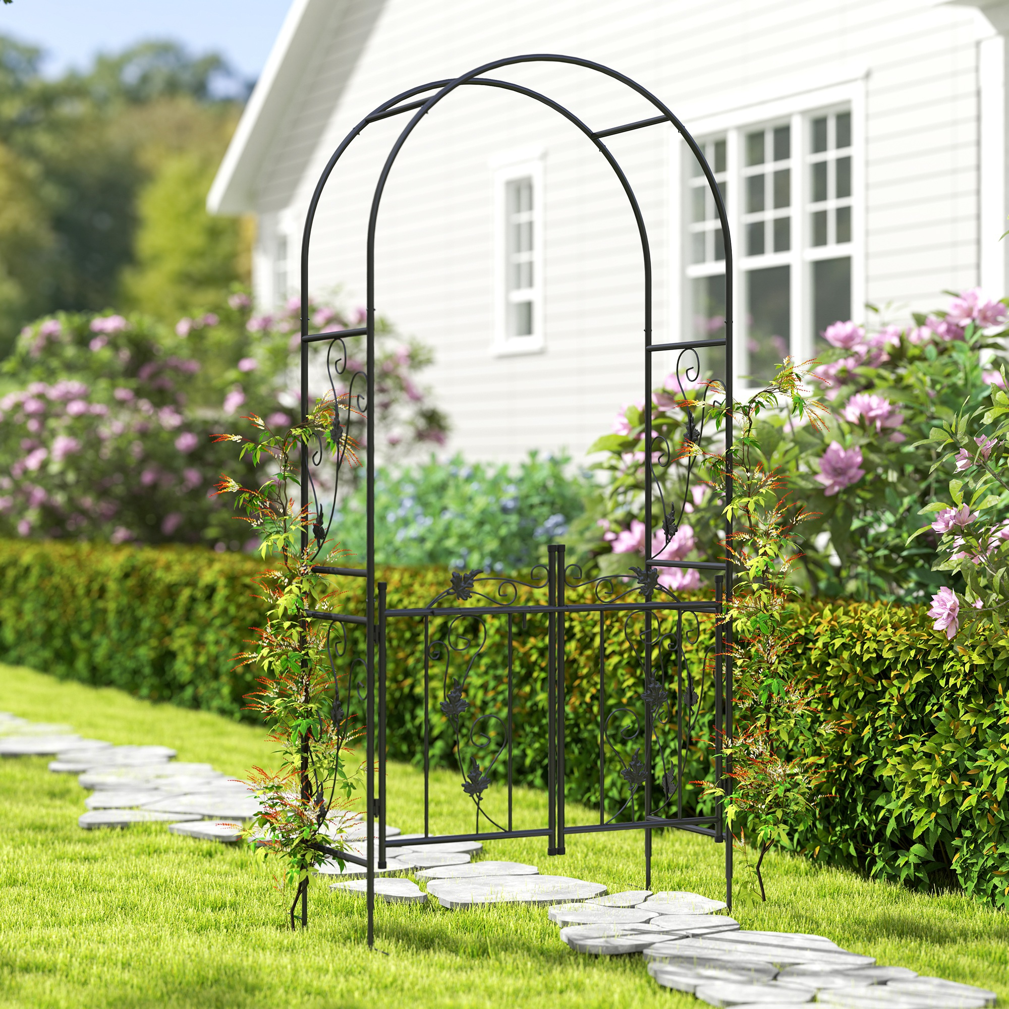 Arco da giardino in metallo nero con piante e un sentiero in pietra.