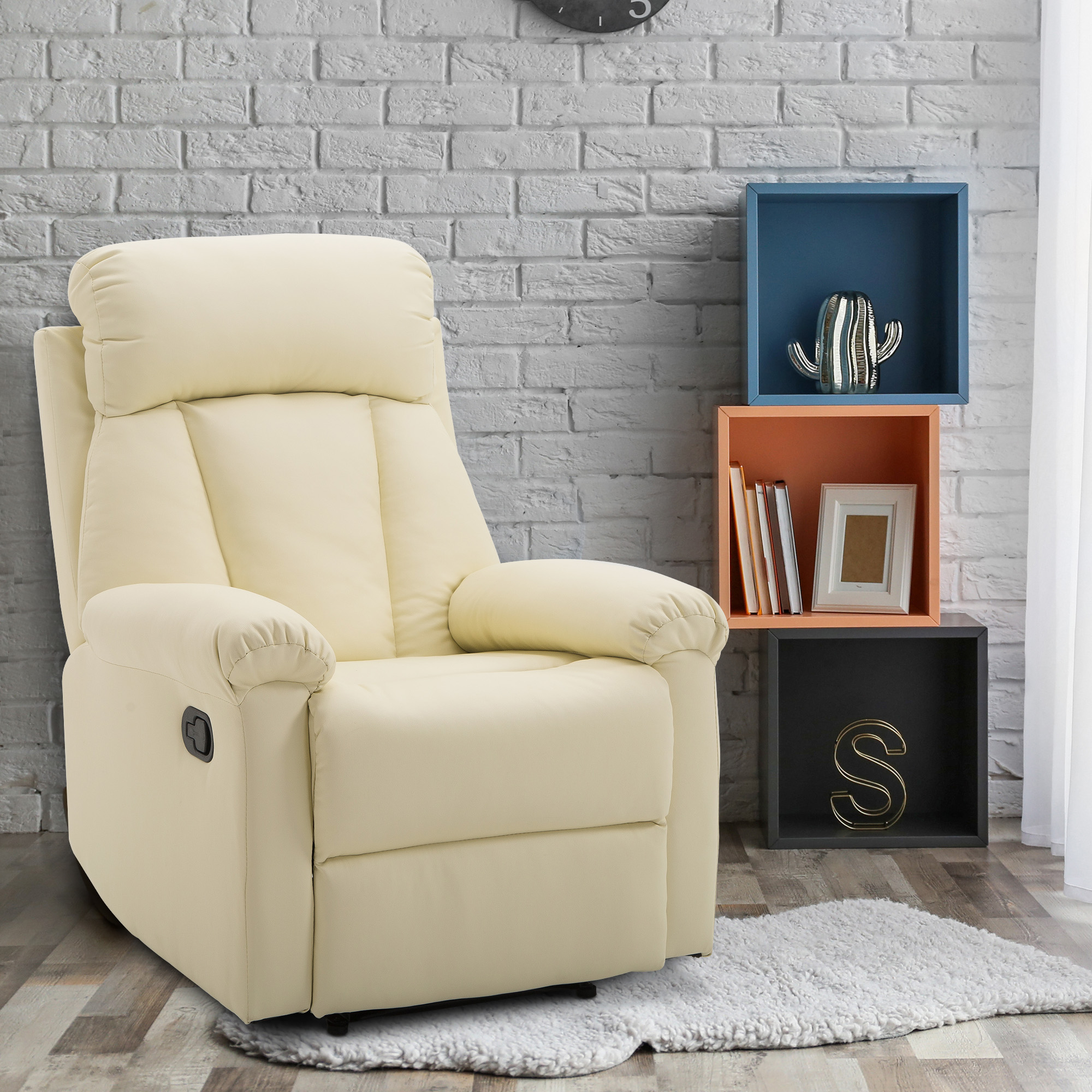Poltrona reclinabile color crema con schienale decorativo, su muro di mattoni con mensole sullo sfondo.