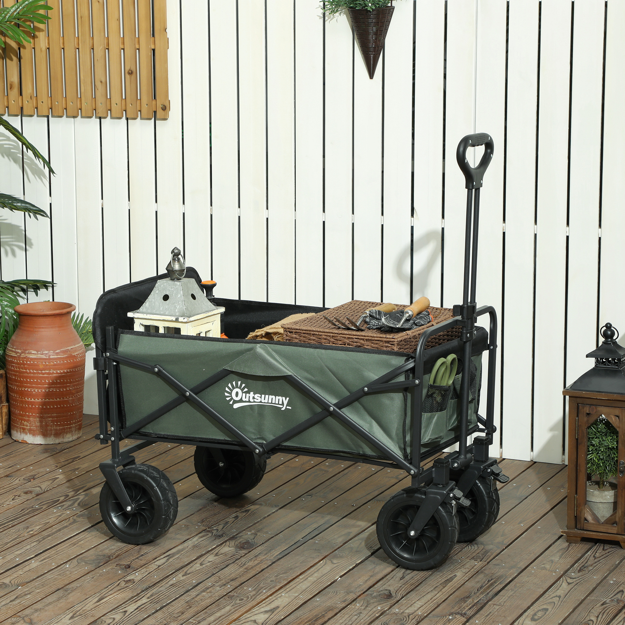 Un carrello verde pieno di attrezzi e articoli da giardinaggio è all'aperto.