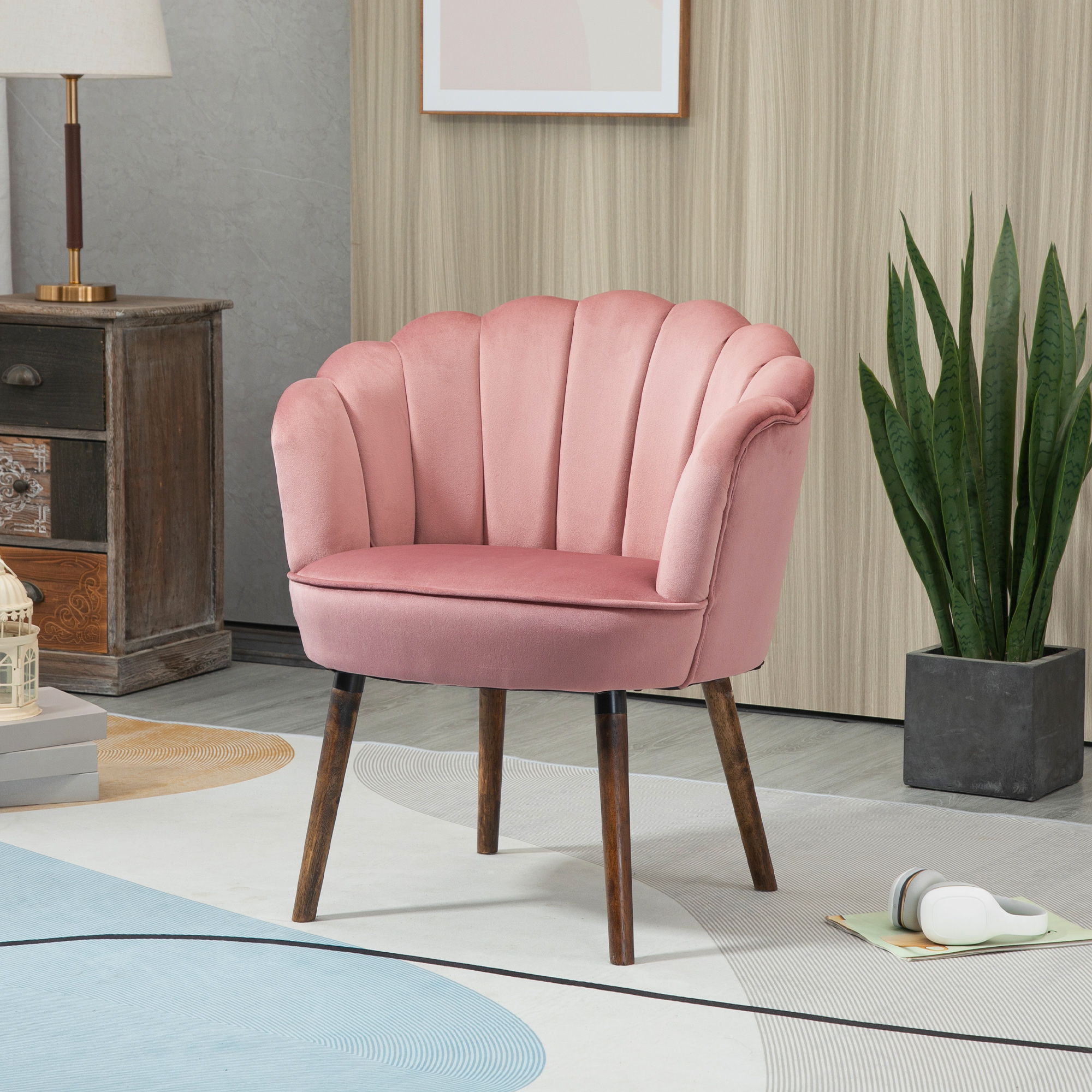 Sedia rosa a forma di conchiglia con gambe in legno. Su un tappeto fantasia.