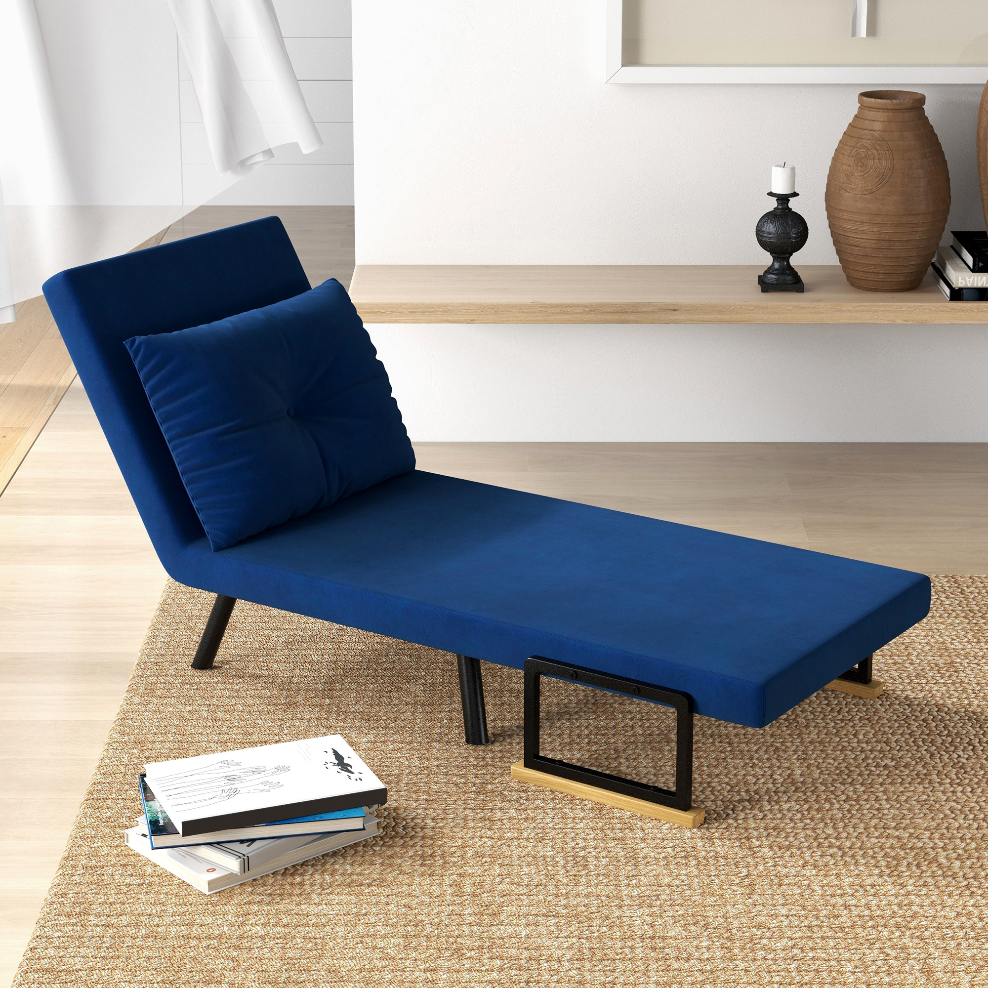 Una chaise longue blu con un cuscino su un tappeto e un tavolino nero.