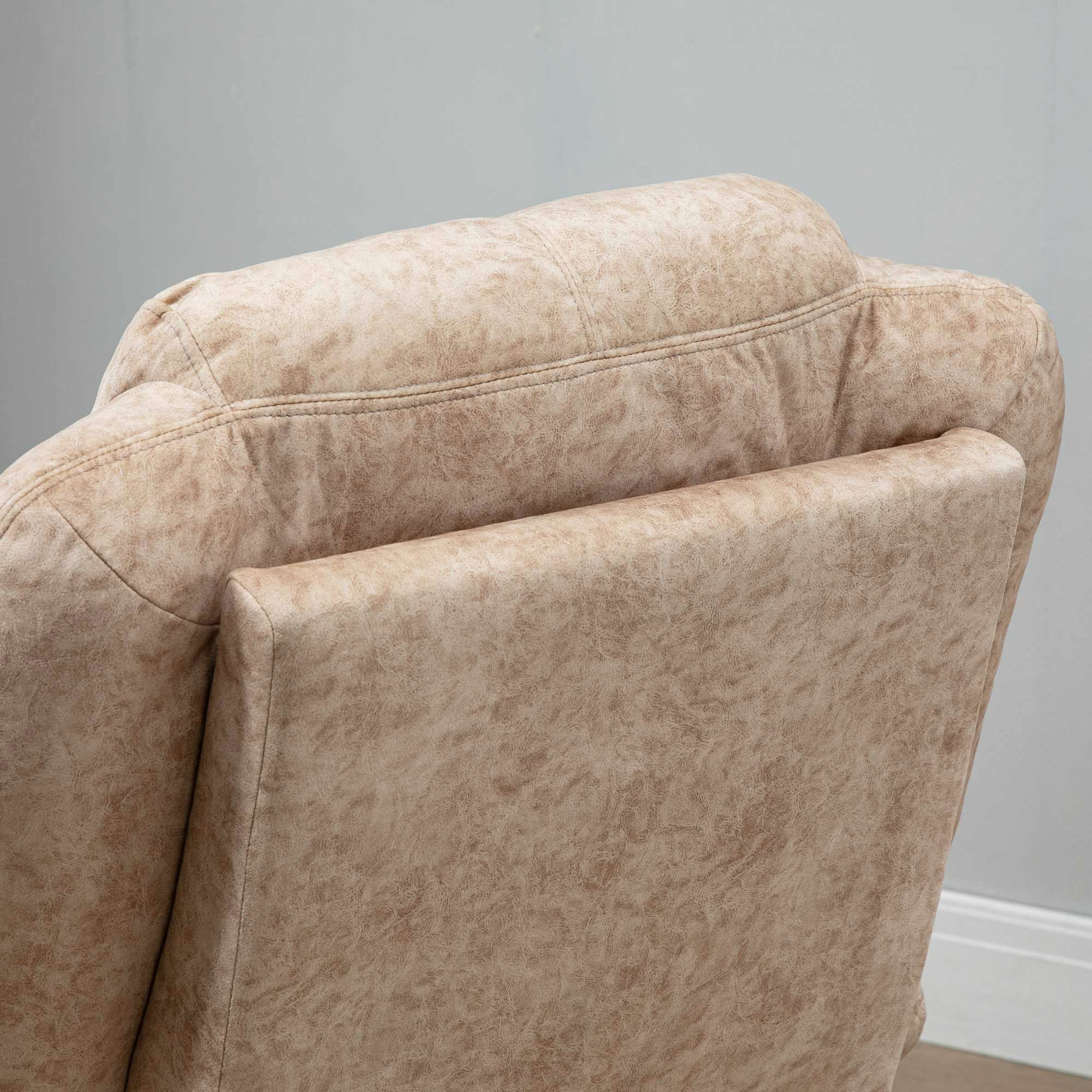 Primo piano dello schienale di una sedia beige. Ha una parte superiore curva. Sono visibili cuciture cucite e una trama a motivi.
