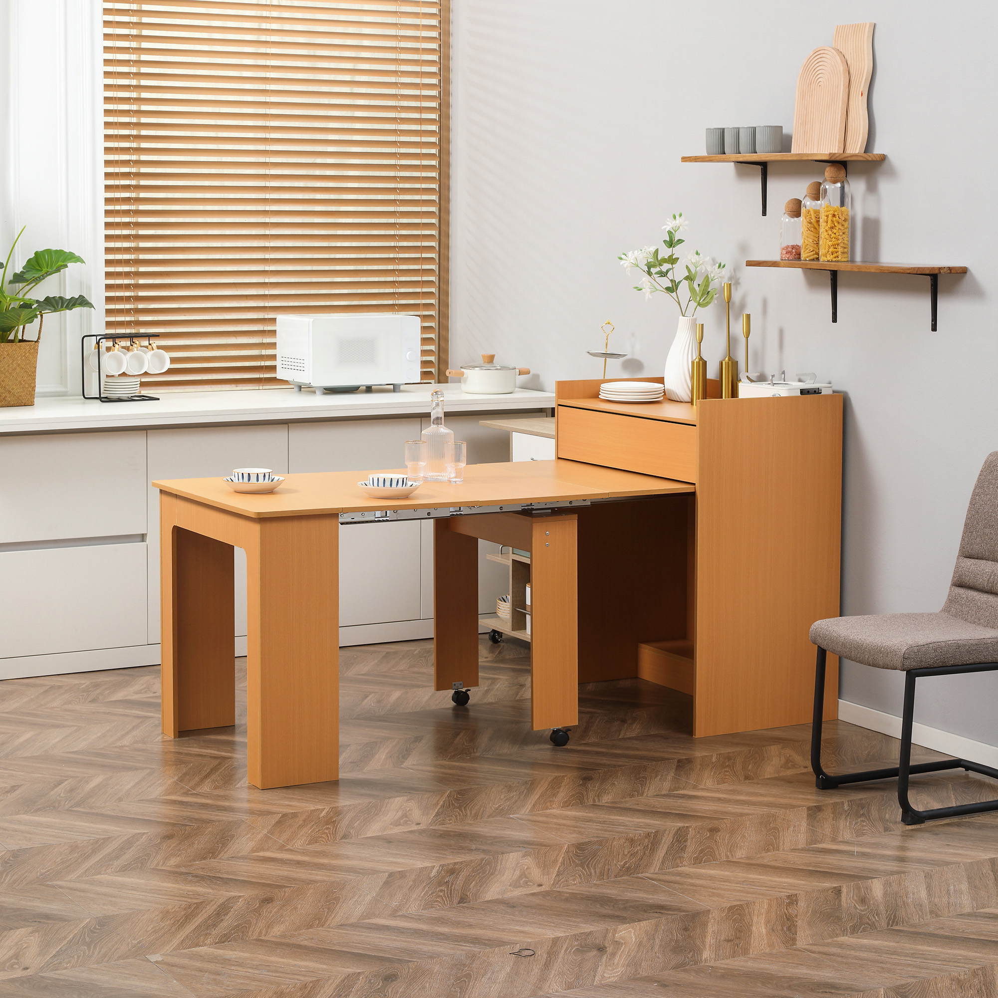 Tavolo da cucina in legno con sezione estraibile. Microonde e mensole sullo sfondo.