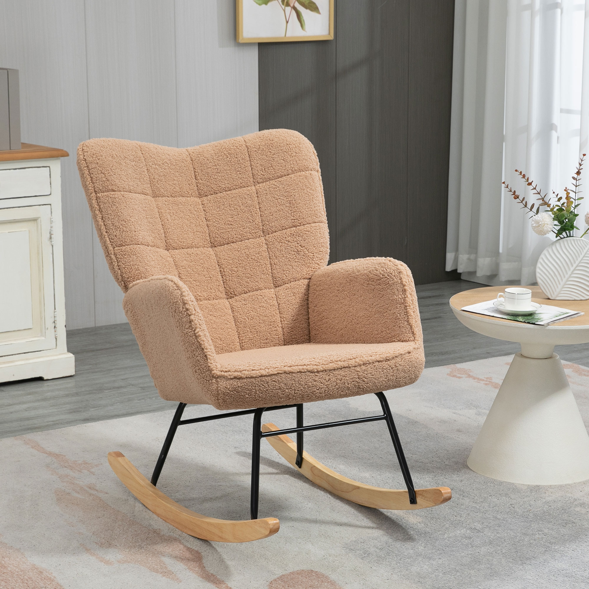Una sedia a dondolo beige con seduta e schienale imbottiti. Ha dondoli in legno e telaio nero.