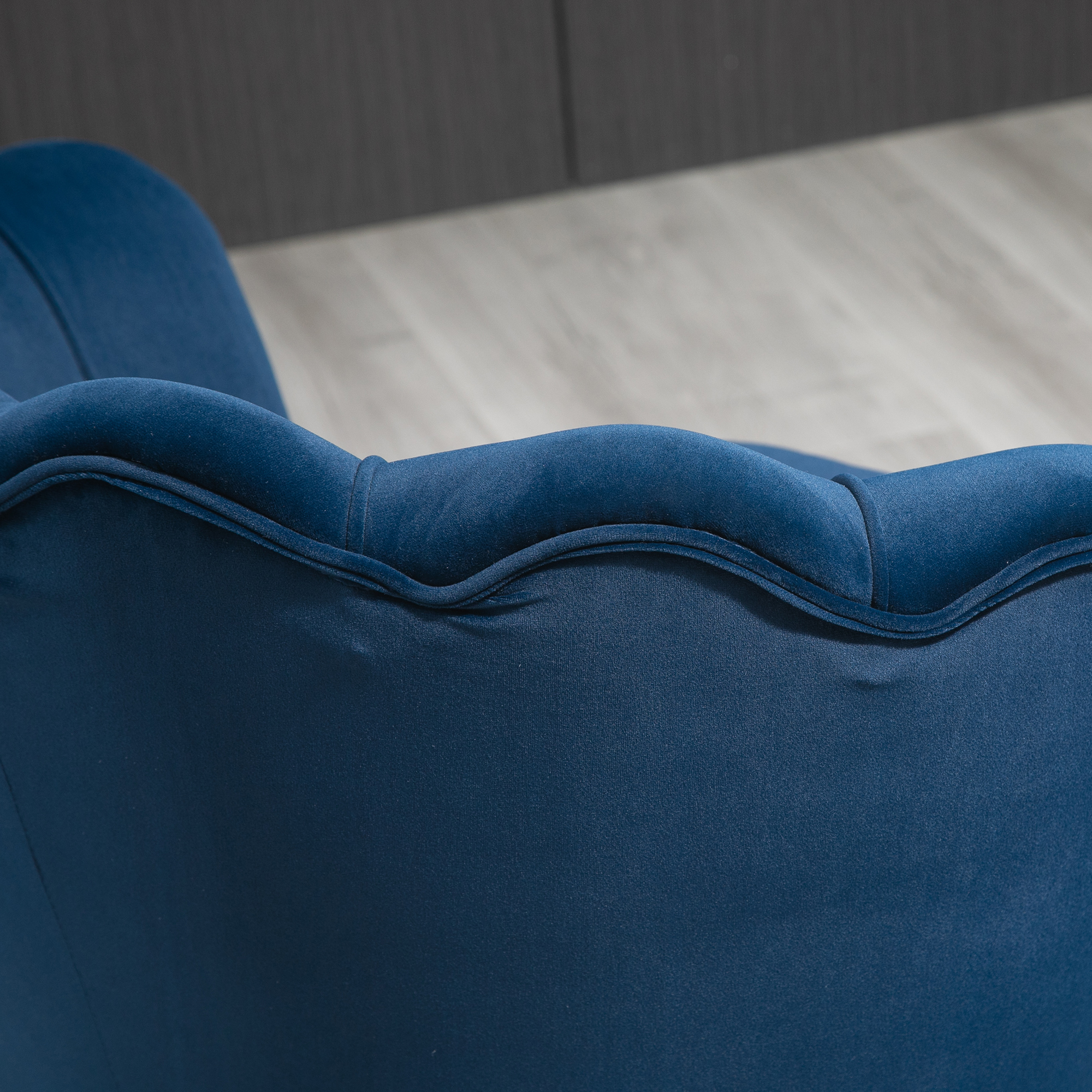 Primo piano dello schienale di una sedia in velluto blu, con design trapuntato.