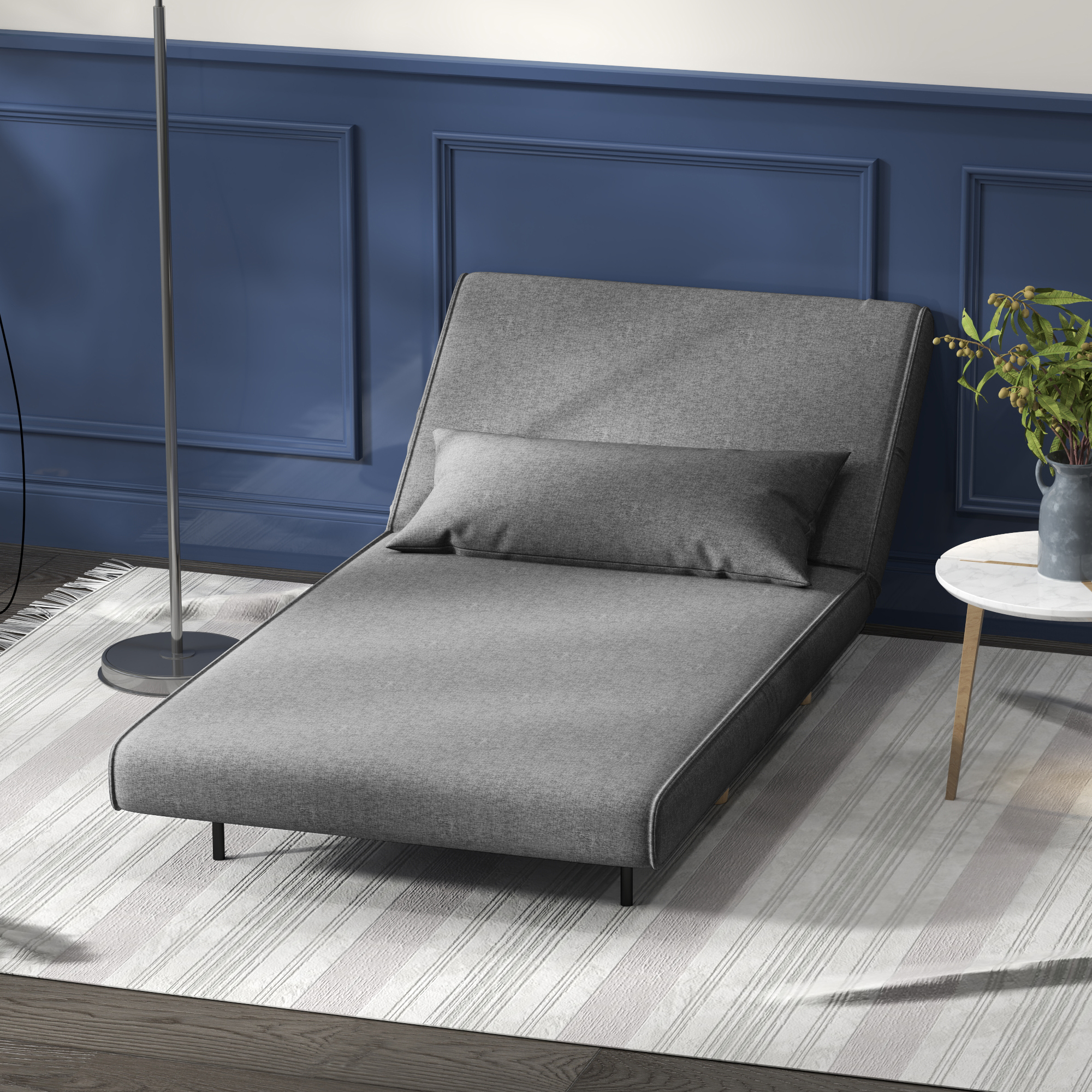 Una chaise longue grigia con un cuscino su un tappeto a righe. Il muro è dipinto di blu.