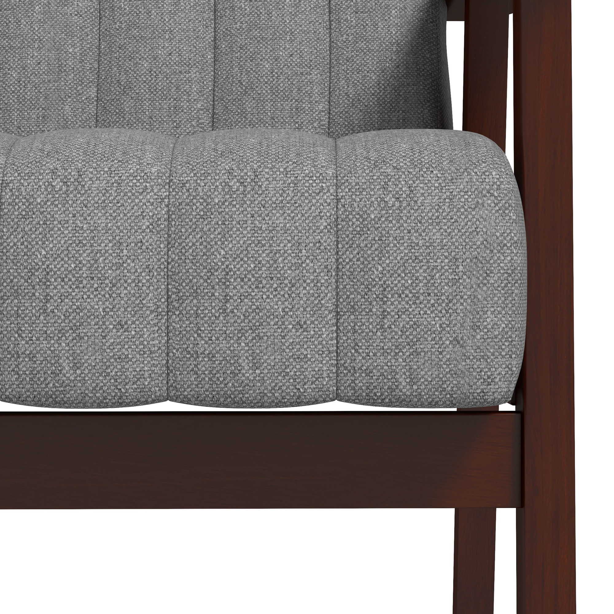 Primo piano di un cuscino di un divano in tessuto grigio e il telaio in legno. Il cuscino ha un design cucito verticale.