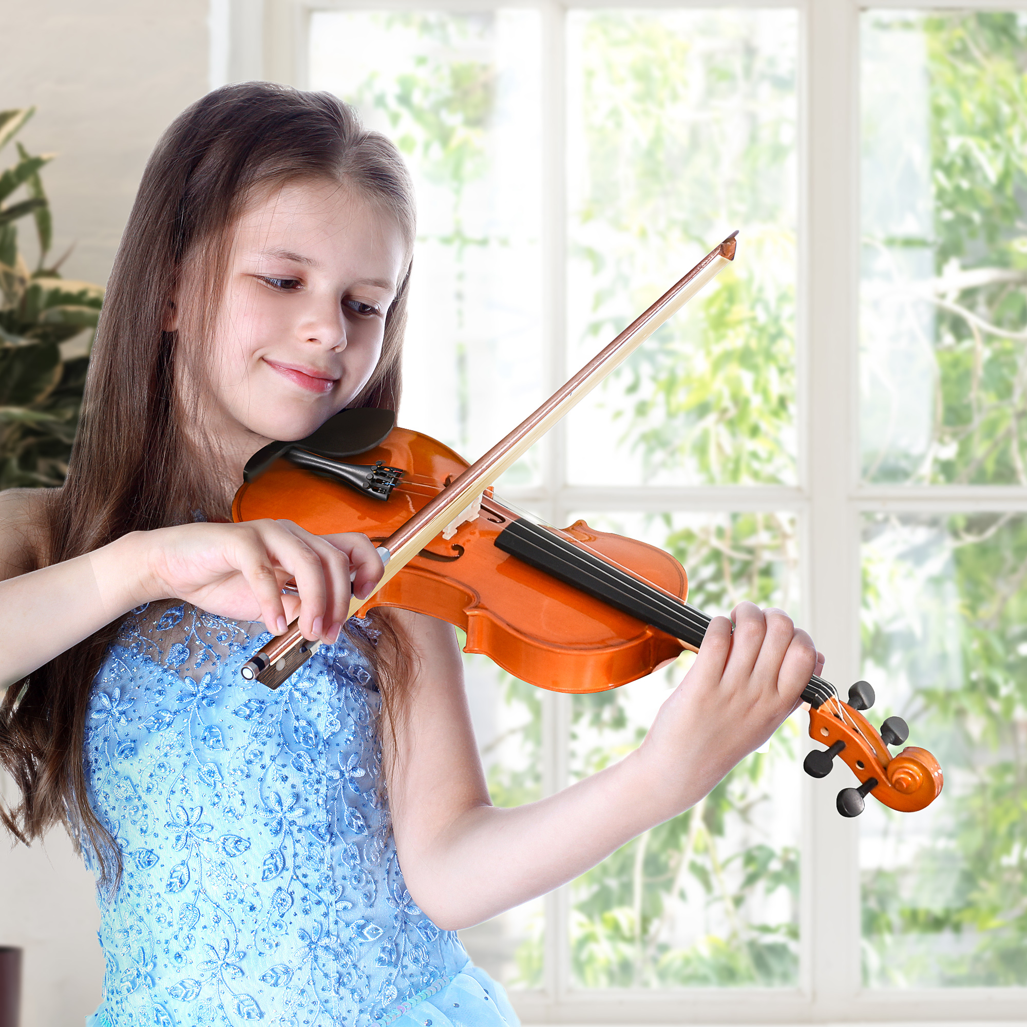 Ragazza suona il violino. Finestra e fogliame verde sullo sfondo.
