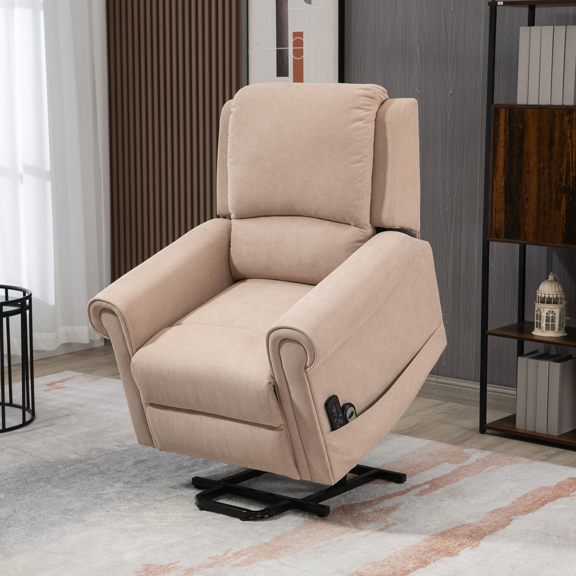 Una poltrona reclinabile beige con base nera, telecomando e tasca laterale, in una stanza con un tappeto e mobili scuri.
