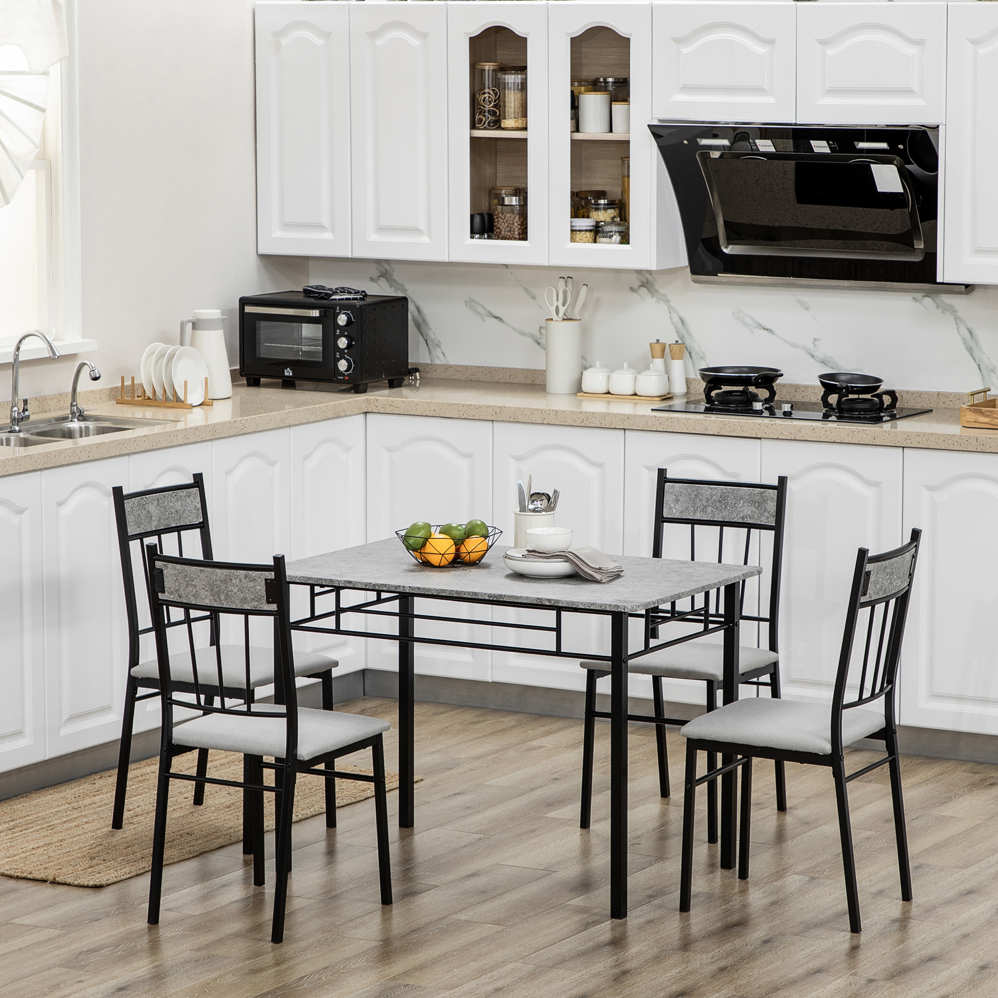 Cucina con tavolo per quattro. Armadi e elettrodomestici bianchi visibili.