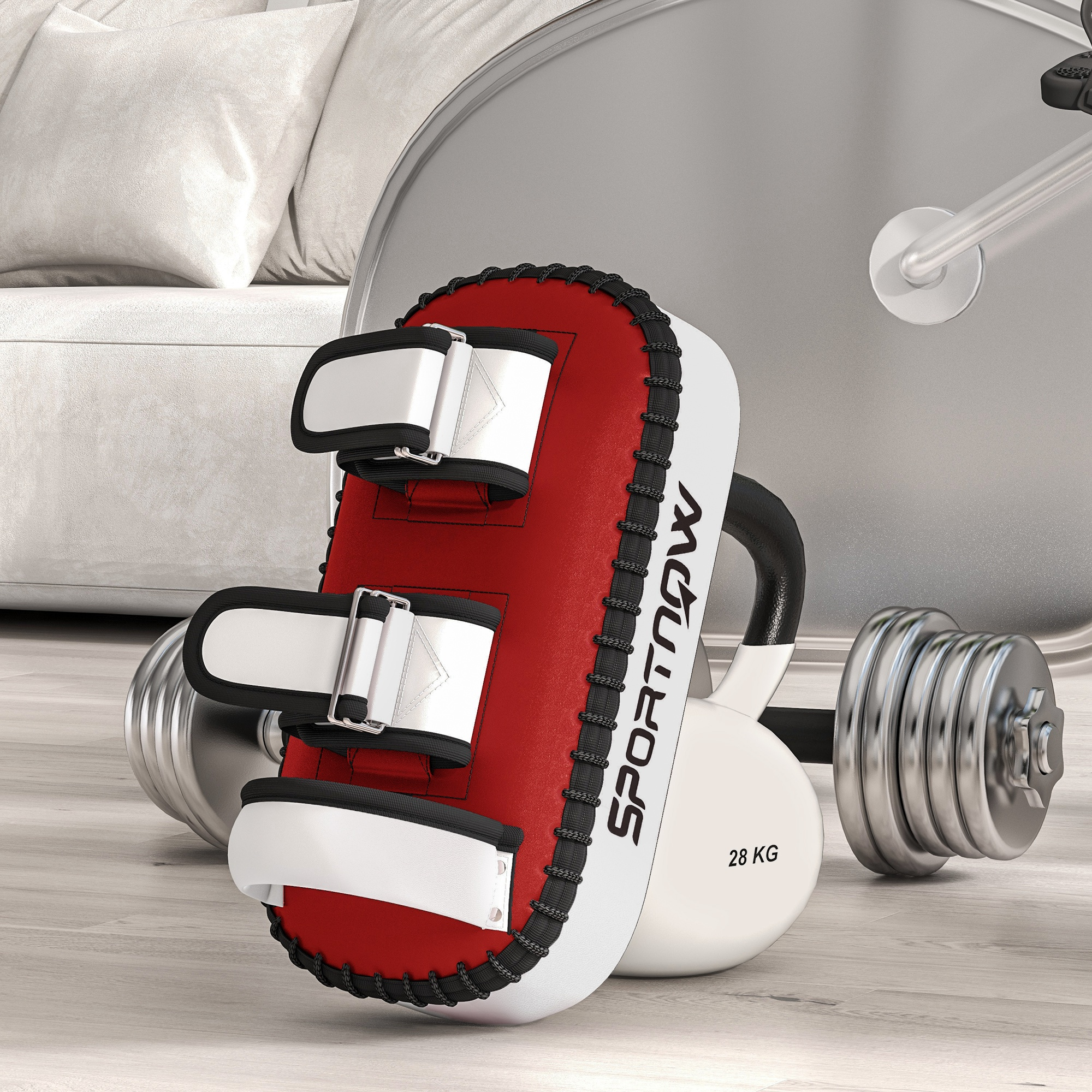 Un paracolpi da kickboxing rosso e bianco è posto vicino a un kettlebell e manubri su un pavimento in legno.