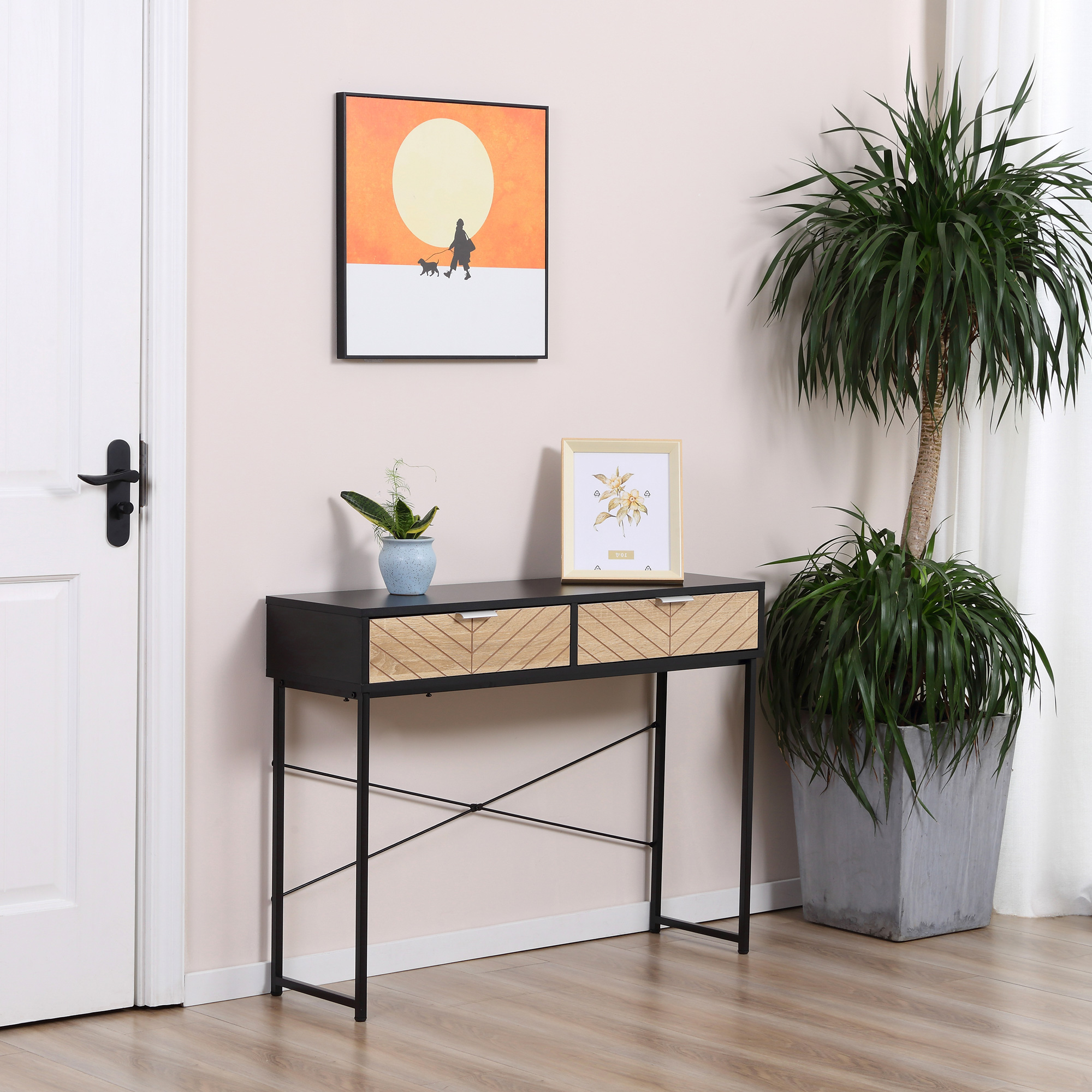 Consolle nera con cassetti e un quadro. Pianta, lampada e porta sullo sfondo.