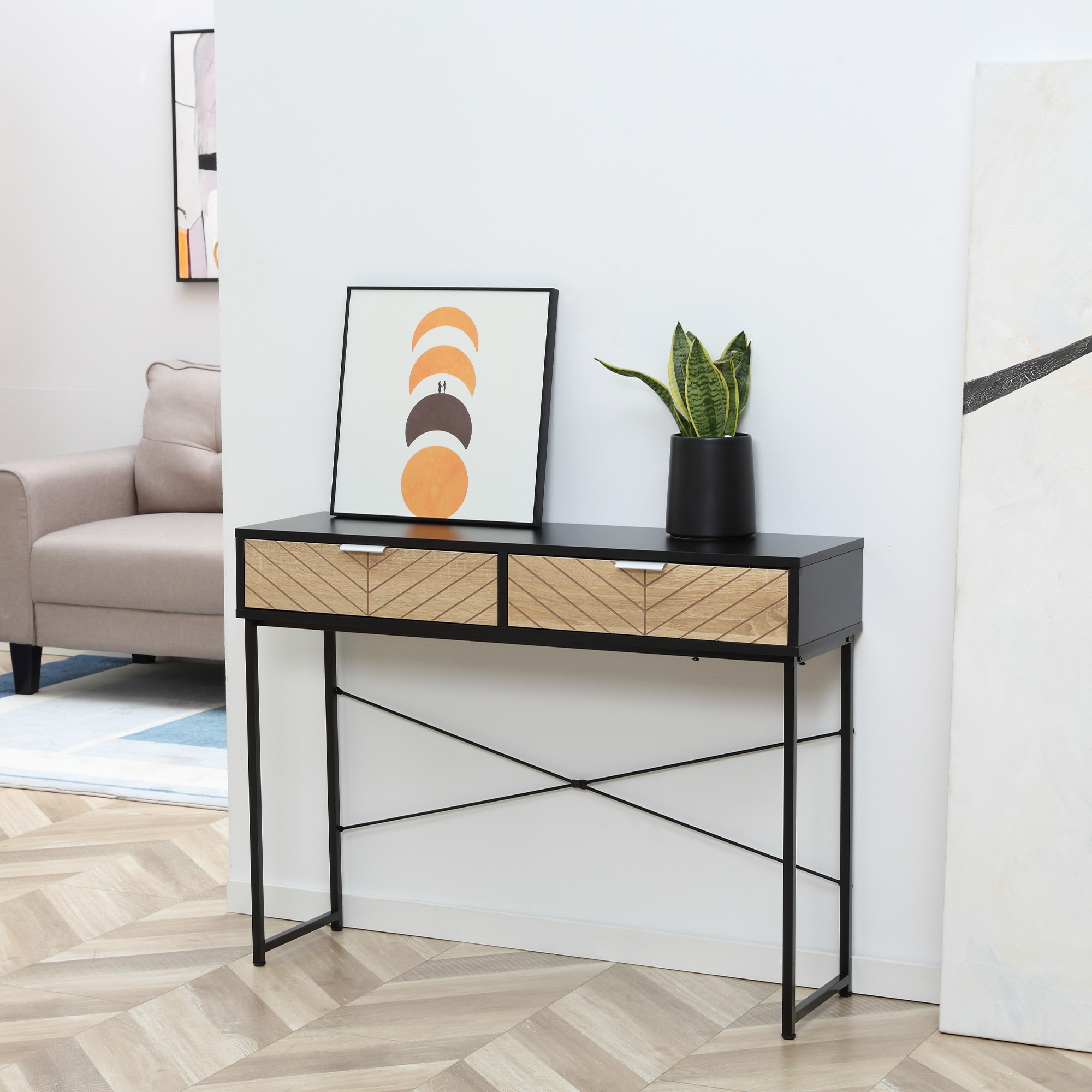 Consolle con cassetti, decorazioni e una pianta. Un muro bianco e pavimento in legno.