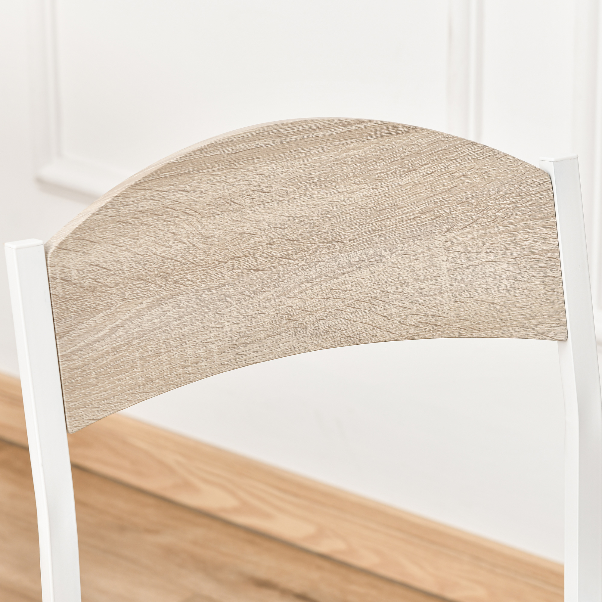 Primo piano dello schienale di una sedia. Venatura del legno chiara, telaio bianco, sfondo neutro.