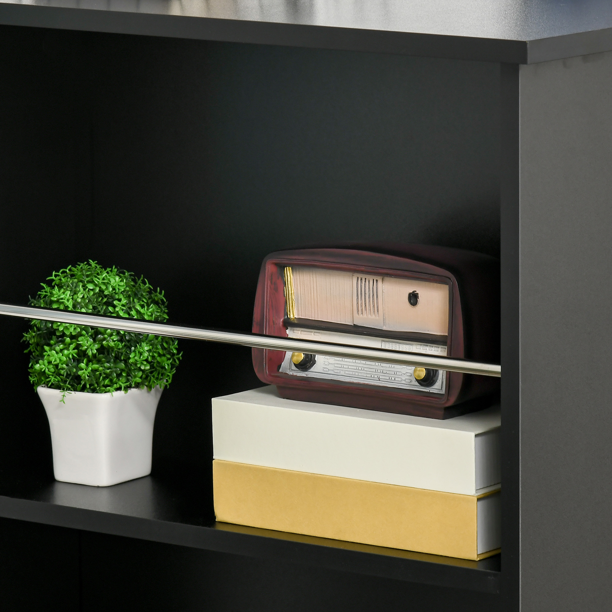 Scaffale con oggetti decorativi: piccola pianta, radio vintage e scatole.