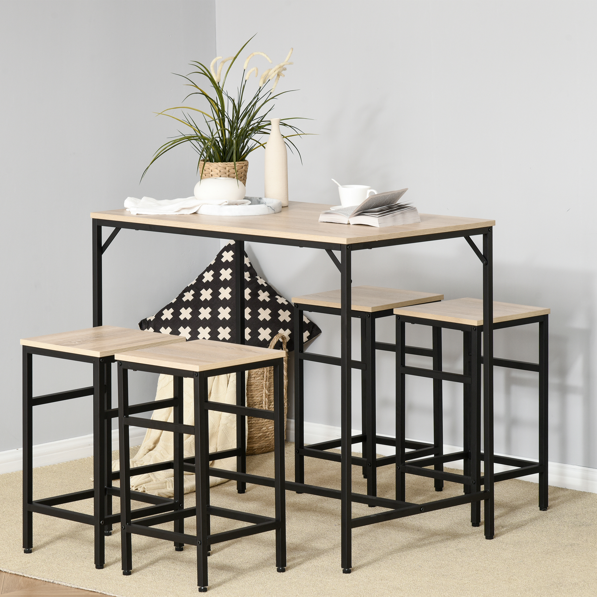 Set da pranzo con tavolo e quattro sgabelli, toni neutri e neri, su tappeto beige.