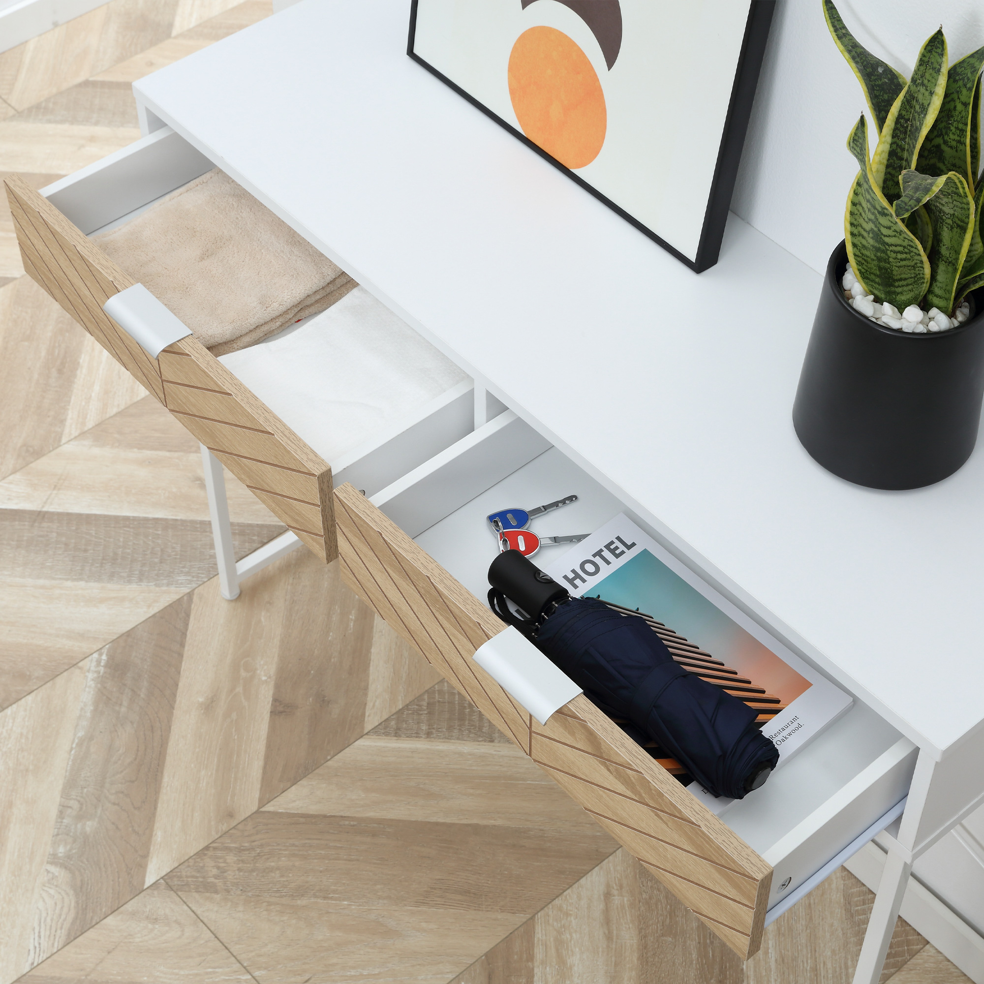 Consolle bianca. Cassetti aperti con oggetti. Pavimento in legno.