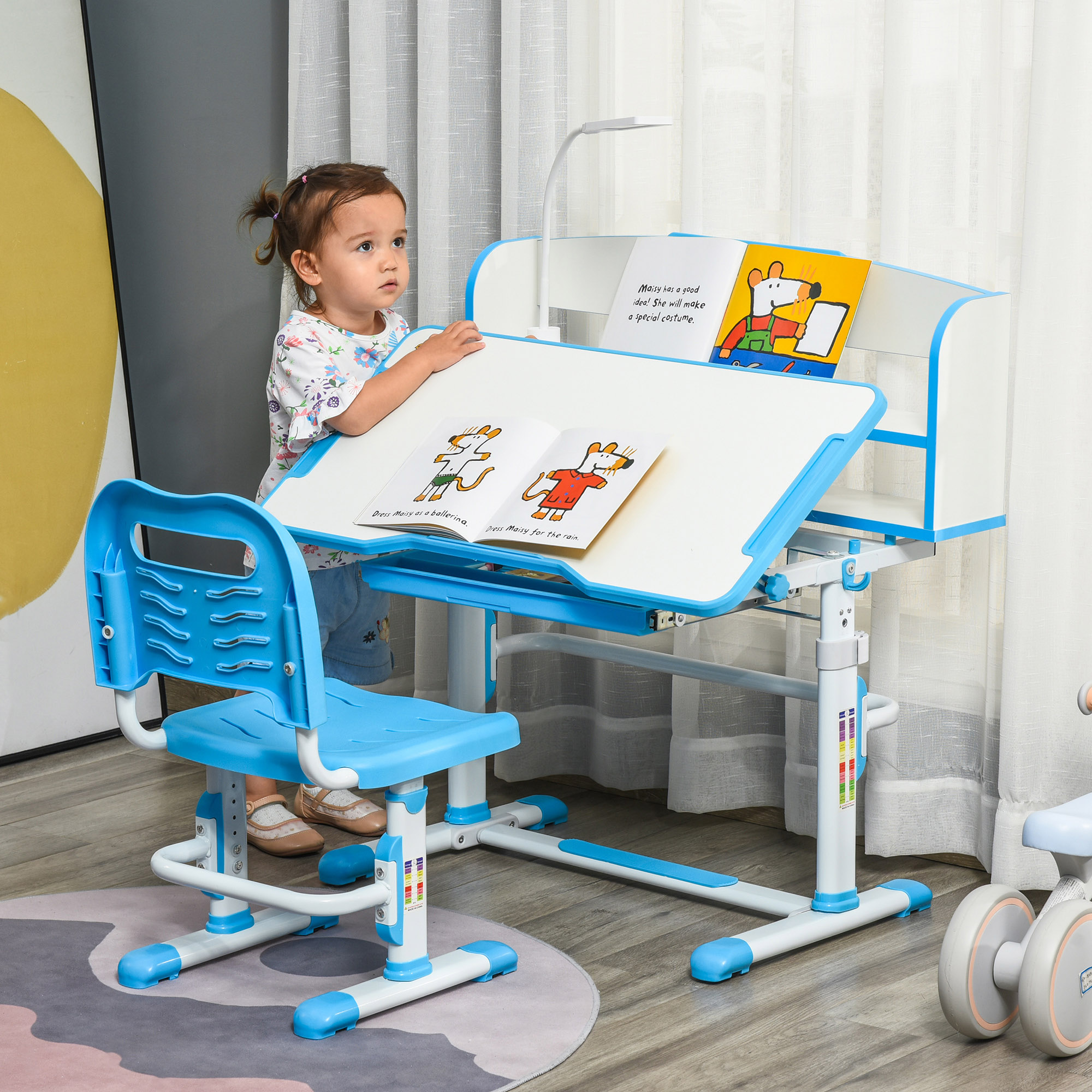 Un set di scrivania e sedia per bambini, blu e bianco. Libri e una lampada sono sulla scrivania.