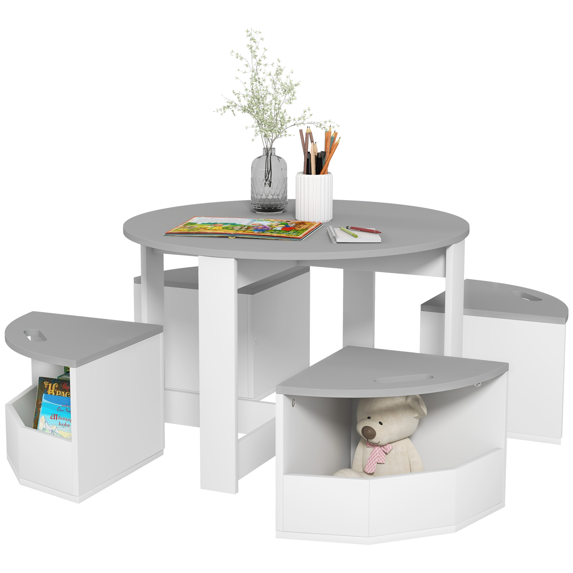Tavolo rotondo grigio e bianco per bambini con quattro sedili triangolari. Un orsacchiotto è seduto in uno.