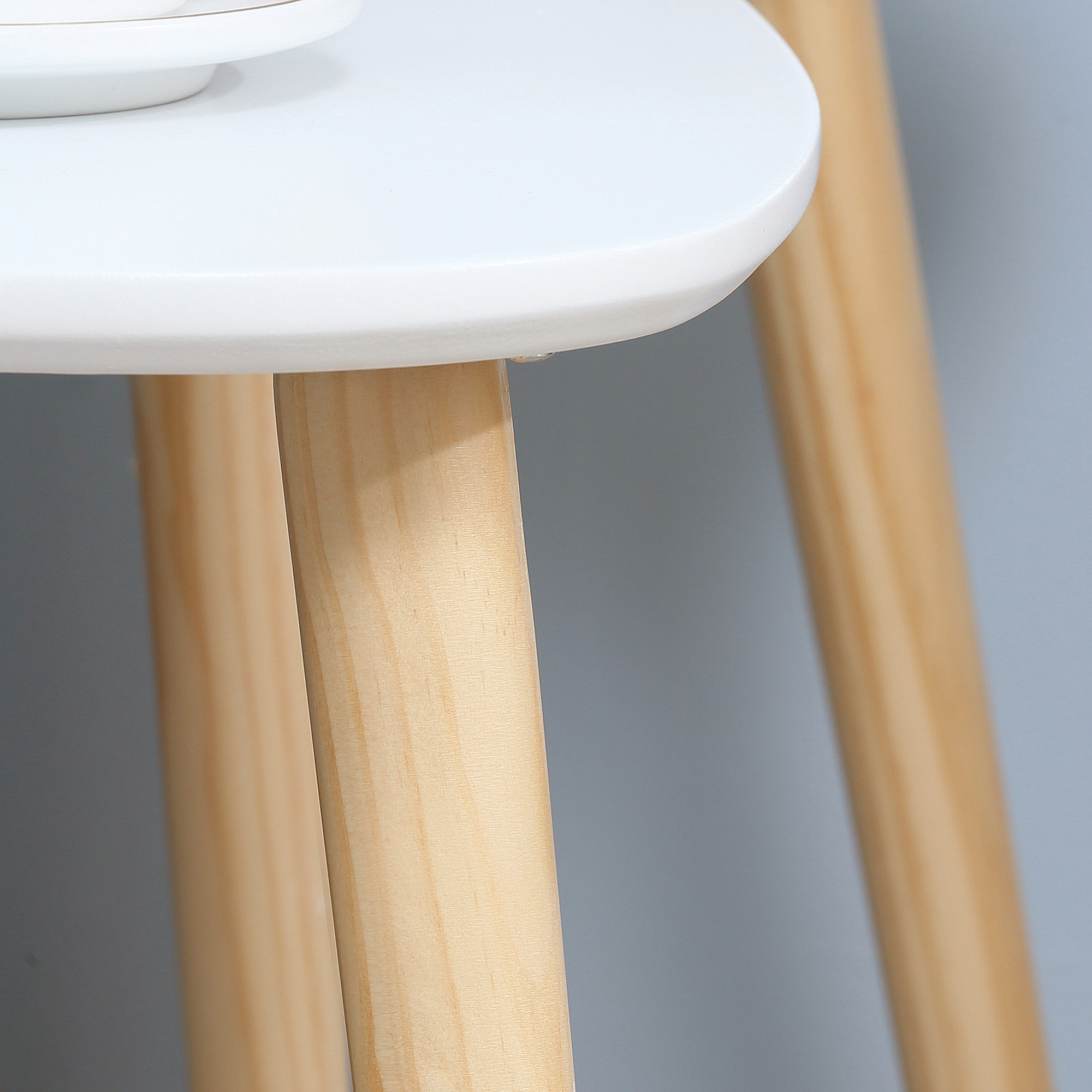 Piano del tavolo bianco con gambe in legno. Una tazza sul tavolo.