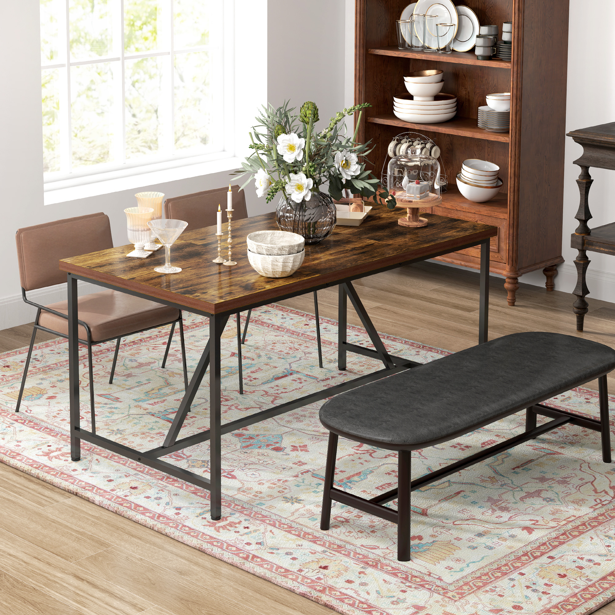 Tavolo da pranzo in legno con sedie e panca. Tappeto, fiori e oggetti decorativi.