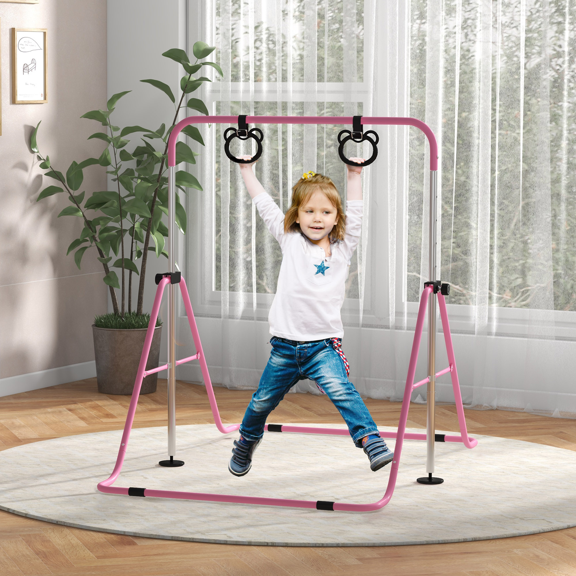 Una bambina appesa a sbarre rosa, sorridente. C'è una pianta e una finestra sullo sfondo.