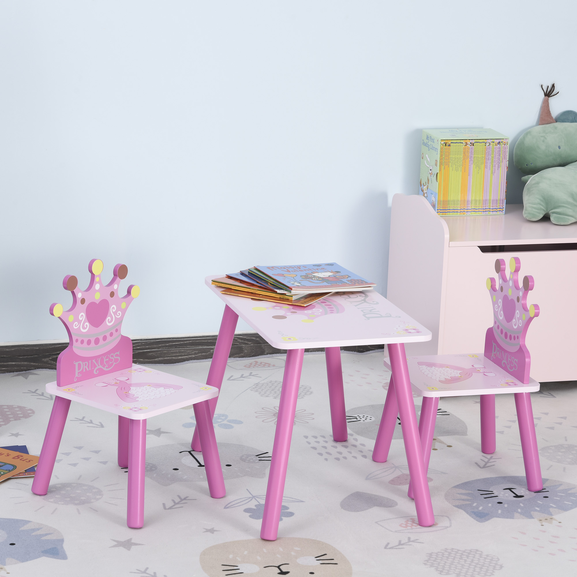 Un set di tavolo e sedie rosa nella stanza di un bambino, con schienali a forma di corona.