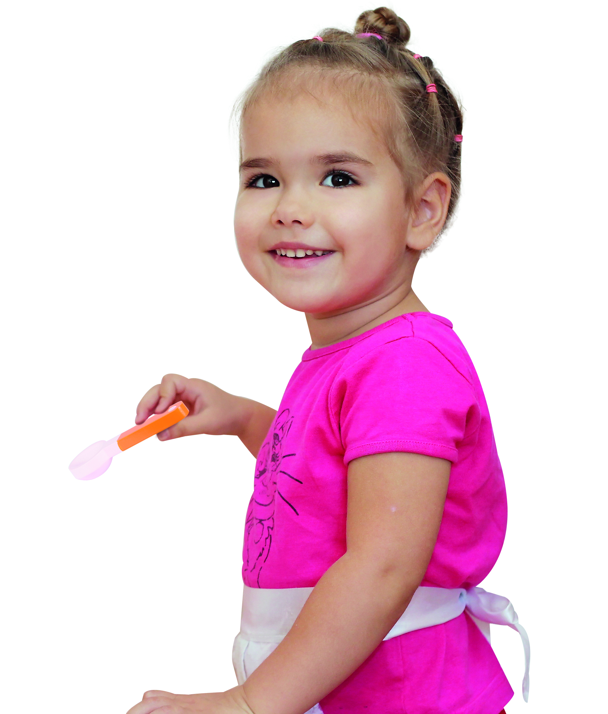 Smiling girl, holding a spoon, wearing a pink shirt and apron, on a white background.