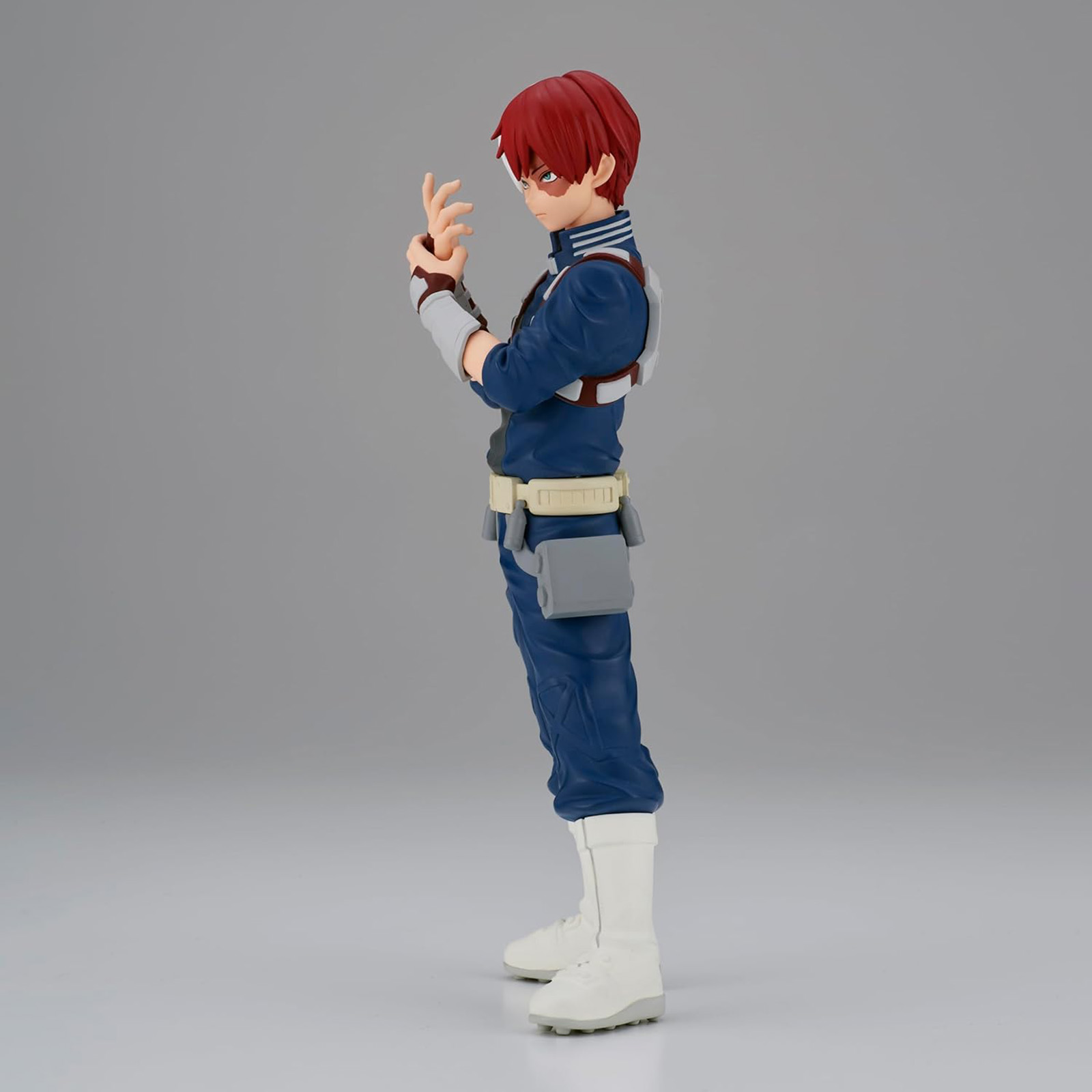 Anime-Charakter-Statue im Profil. Eine männliche Figur mit roten Haaren, die eine blau-weiße Uniform trägt.