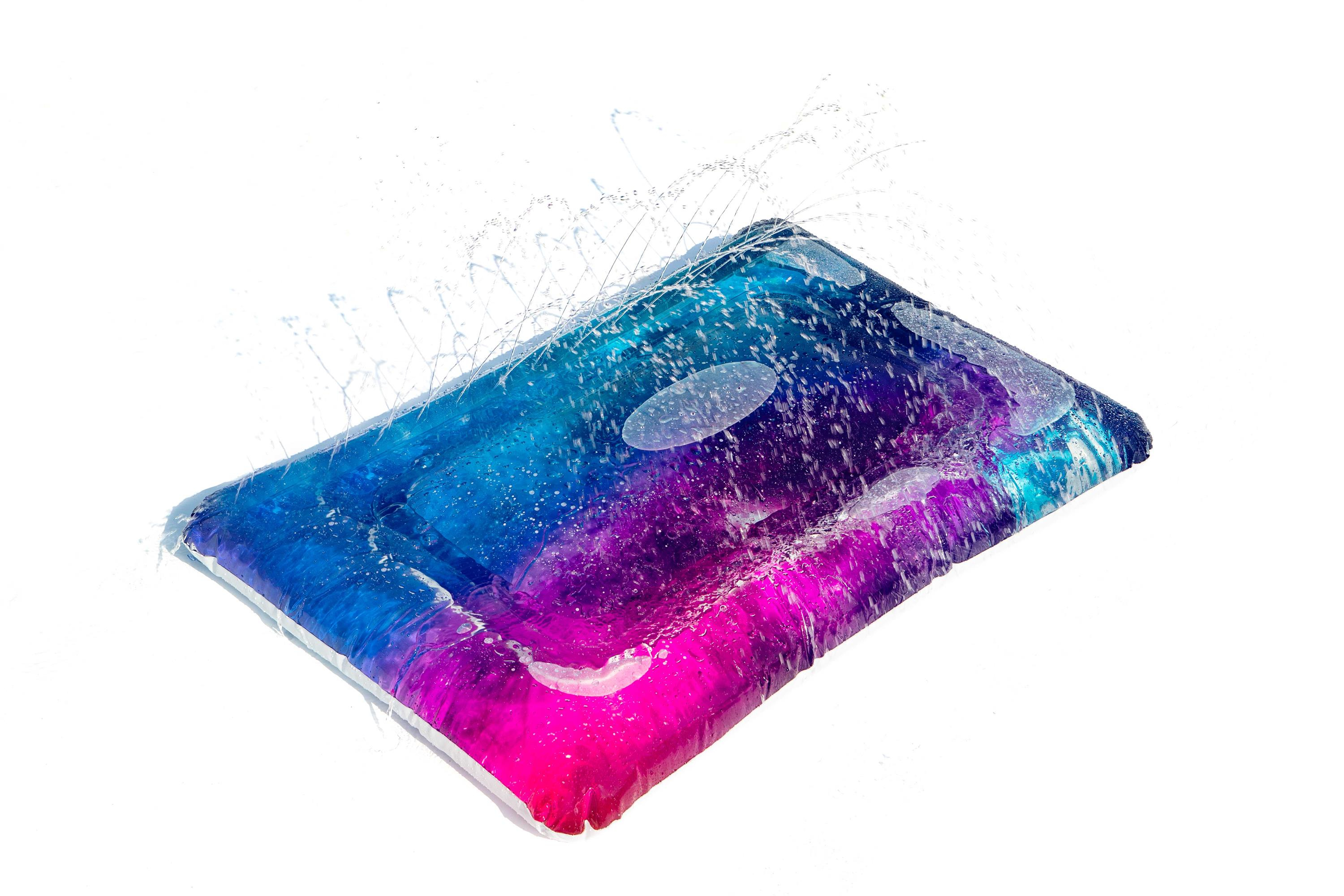 Een rechthoekige opblaasbare waterpad met kleurrijke tinten en waterspatten op een witte achtergrond.
