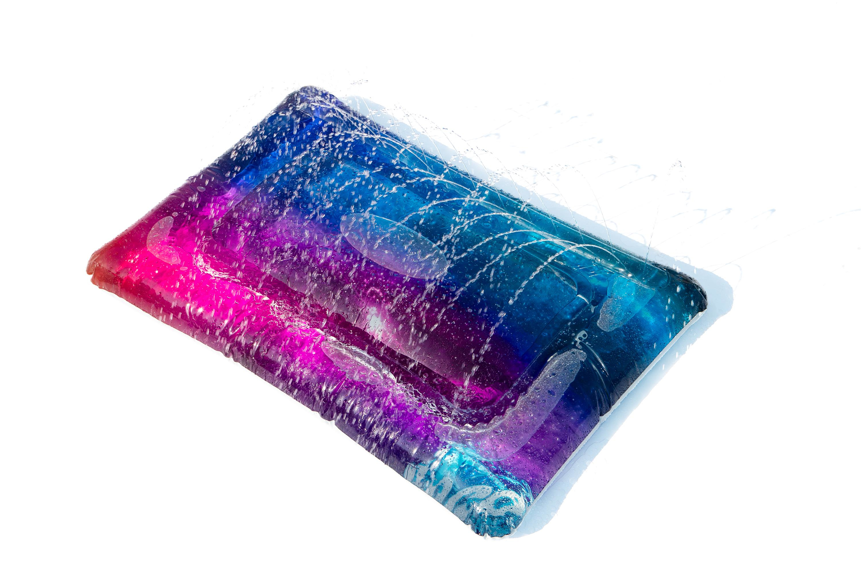 Een rechthoekig speeltje is gevuld met kleurrijke vloeistof, waardoor een galaxy-effect ontstaat.